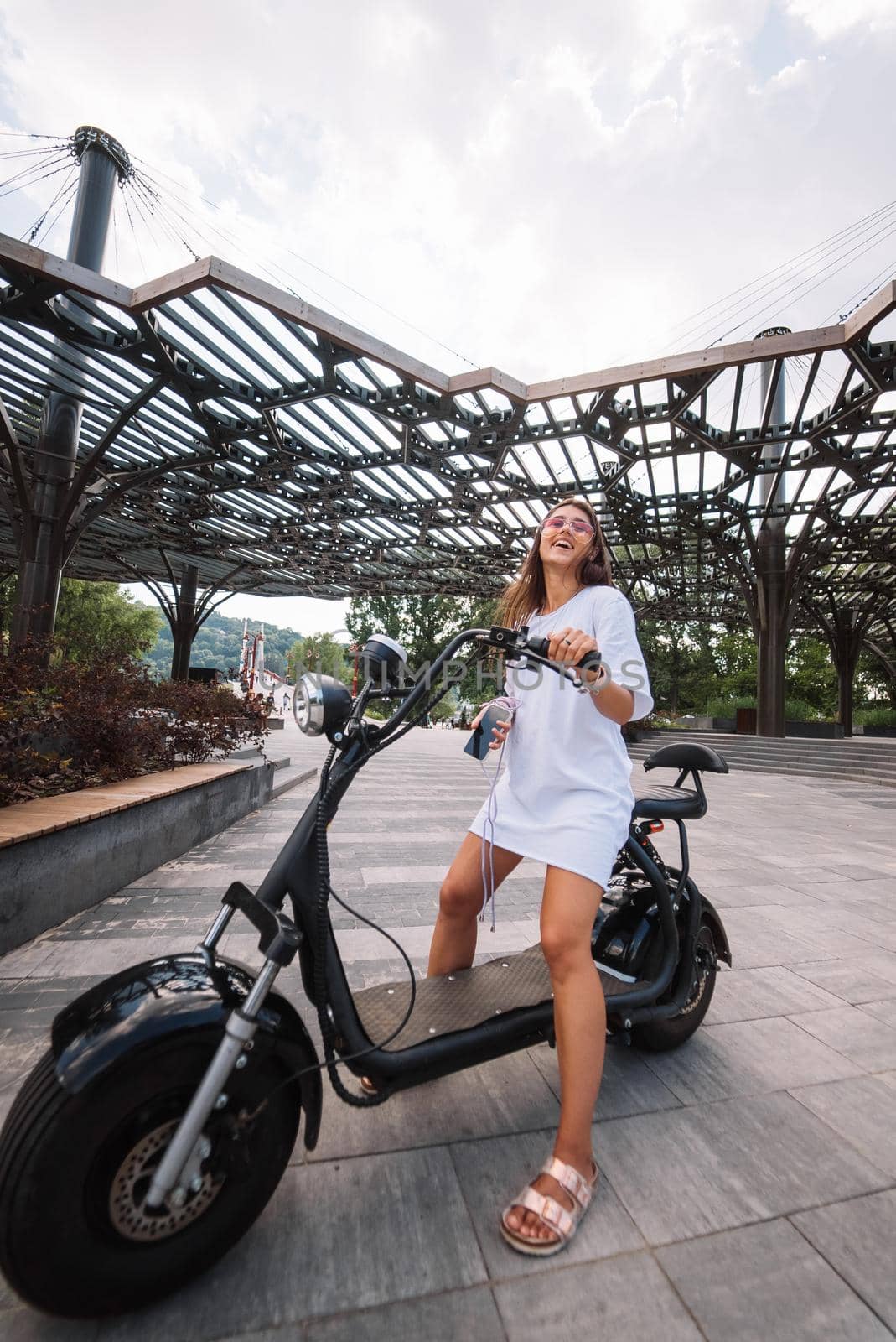 Young beautiful woman and an electric scooter, modern girl, new generation, electric transport, ecological transport