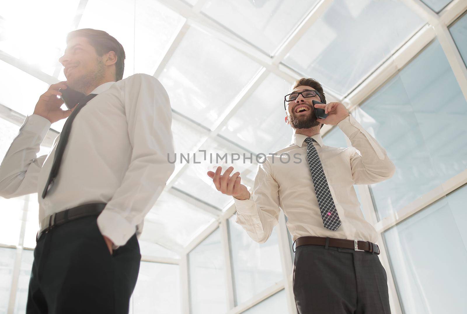 bottom view.business people talking on their mobile phone in the office.the concept of communication