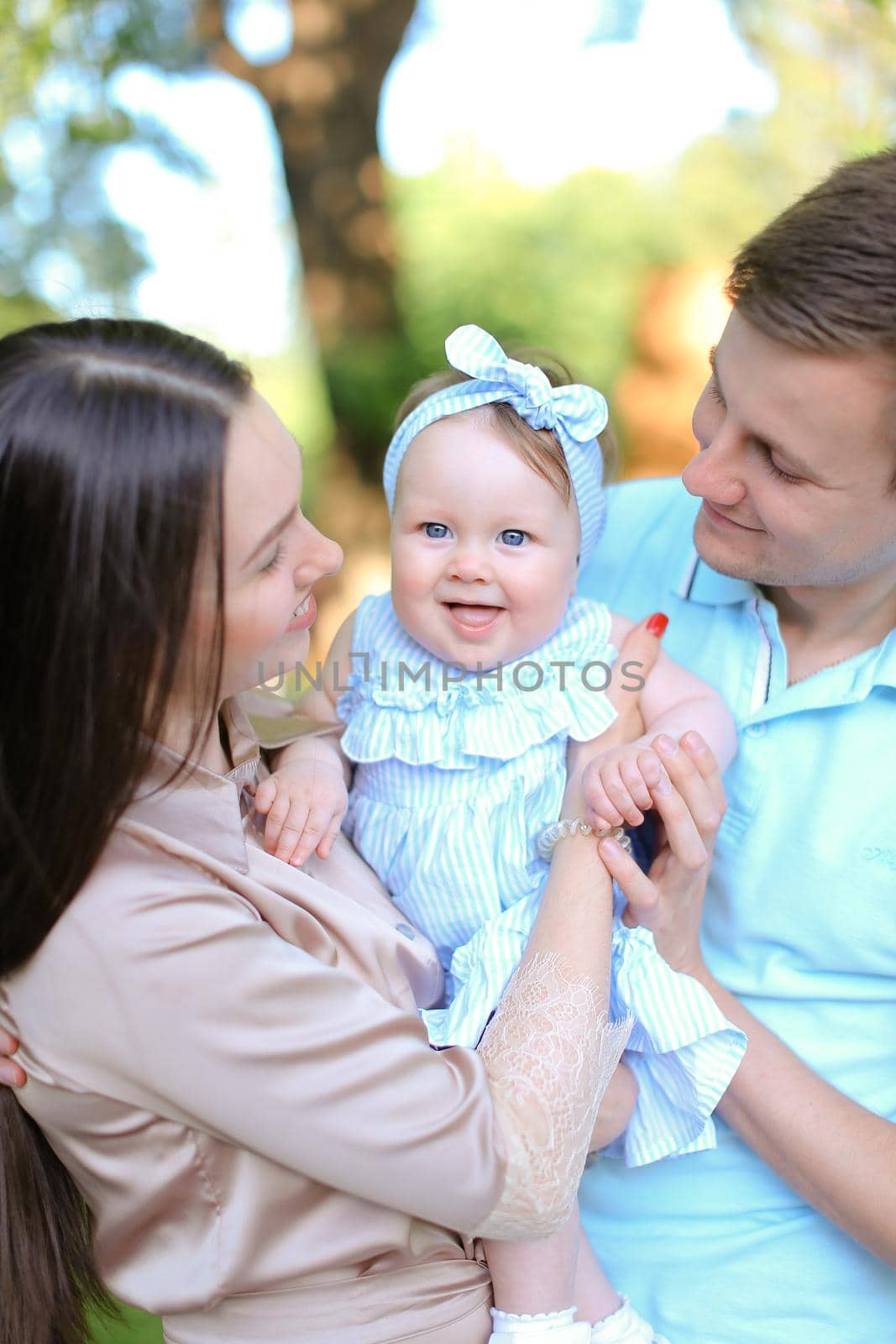 Young happy parents holding little daughter. by sisterspro
