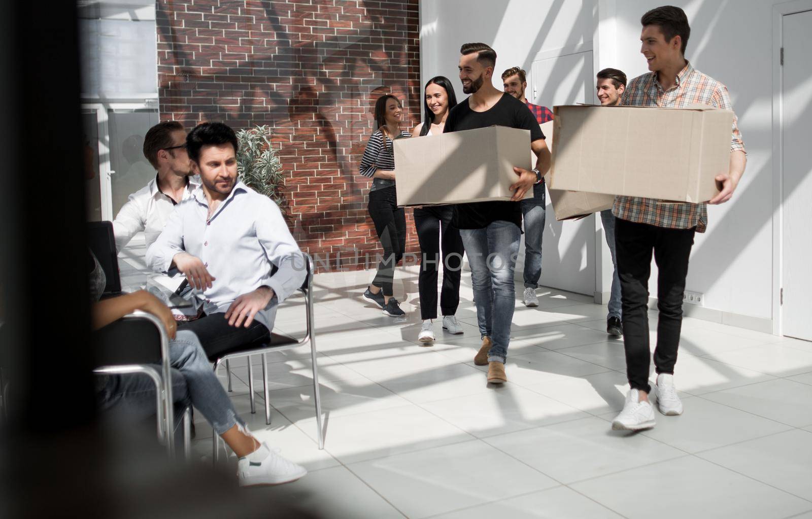 creative business team brings cardboard boxes to the new office by asdf