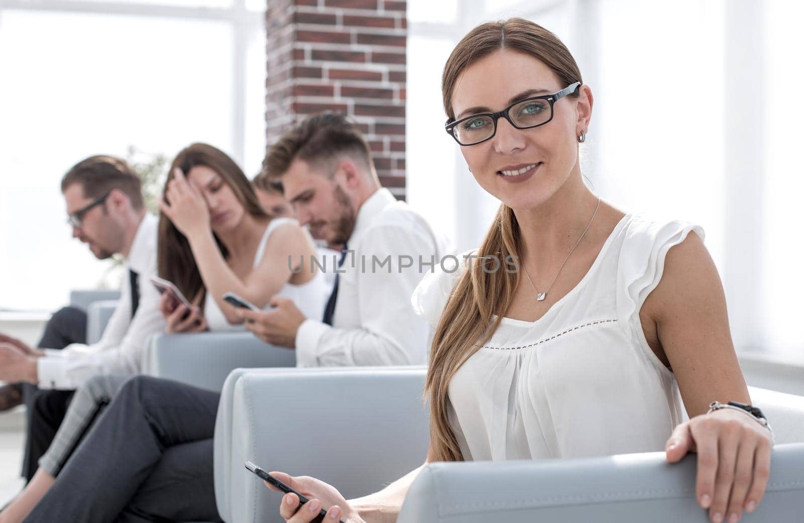 young business woman sitting in office waiting room.people and technology