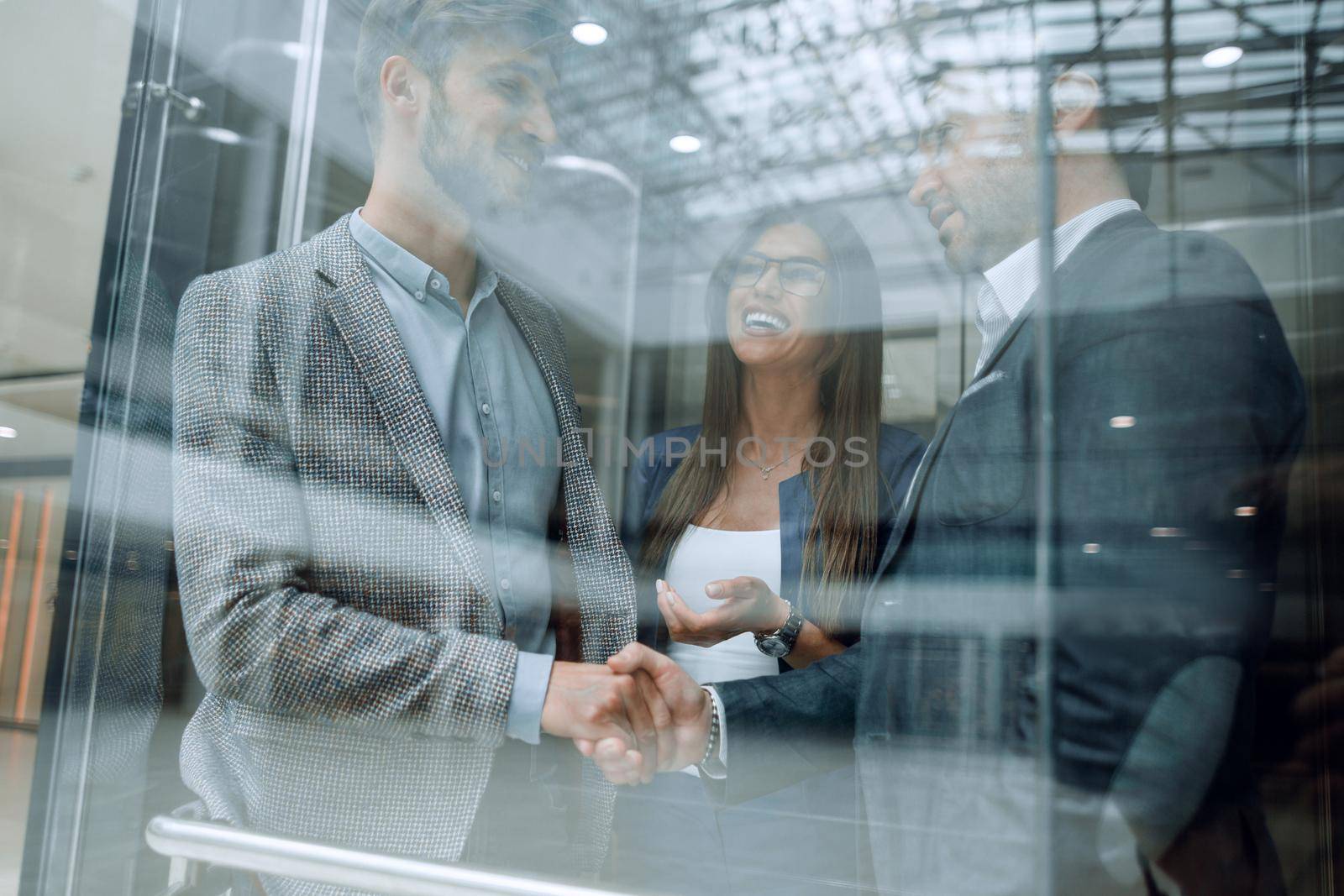 colleagues shaking hands in the Elevato by asdf