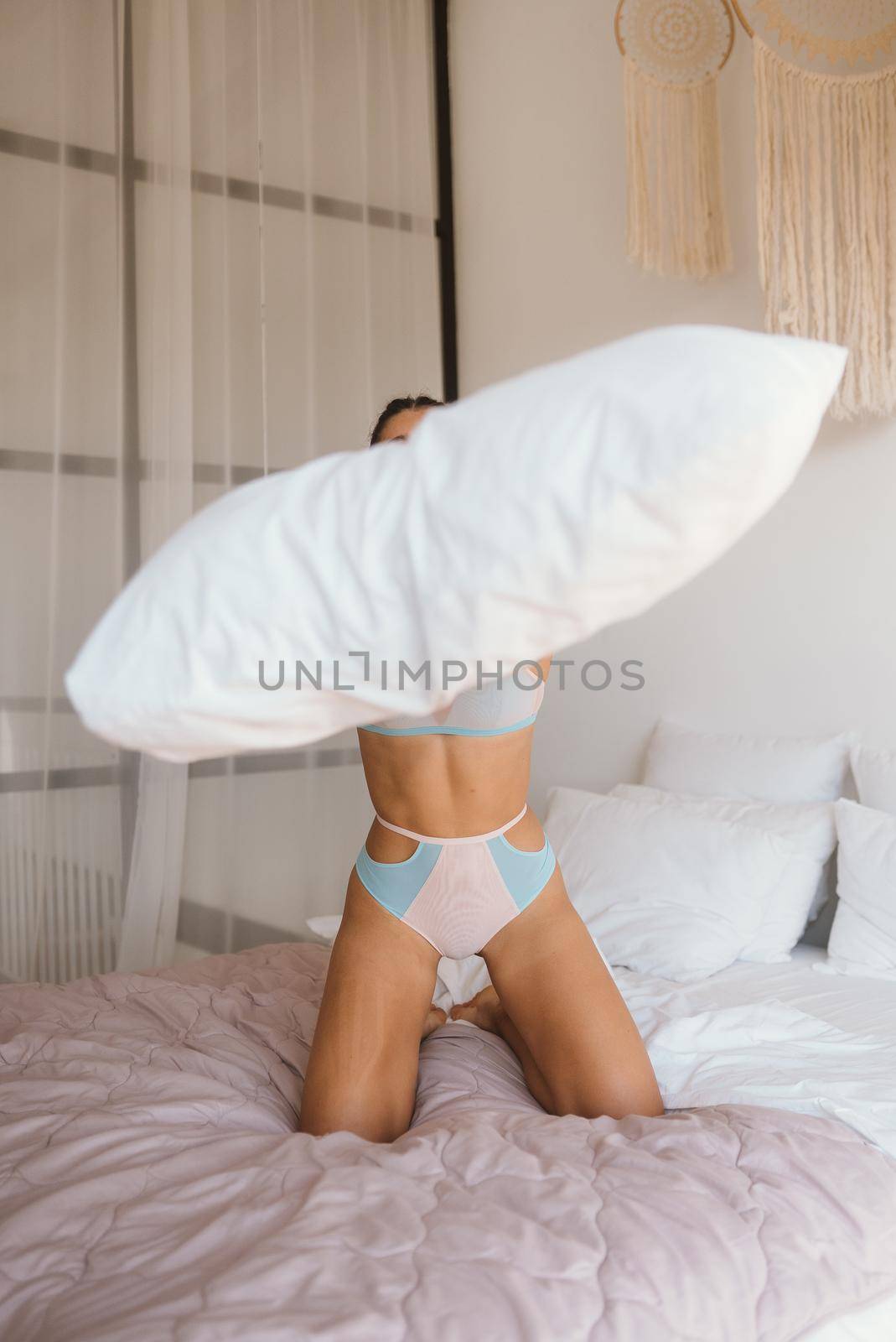 Woman in lingerie playing with her pillow