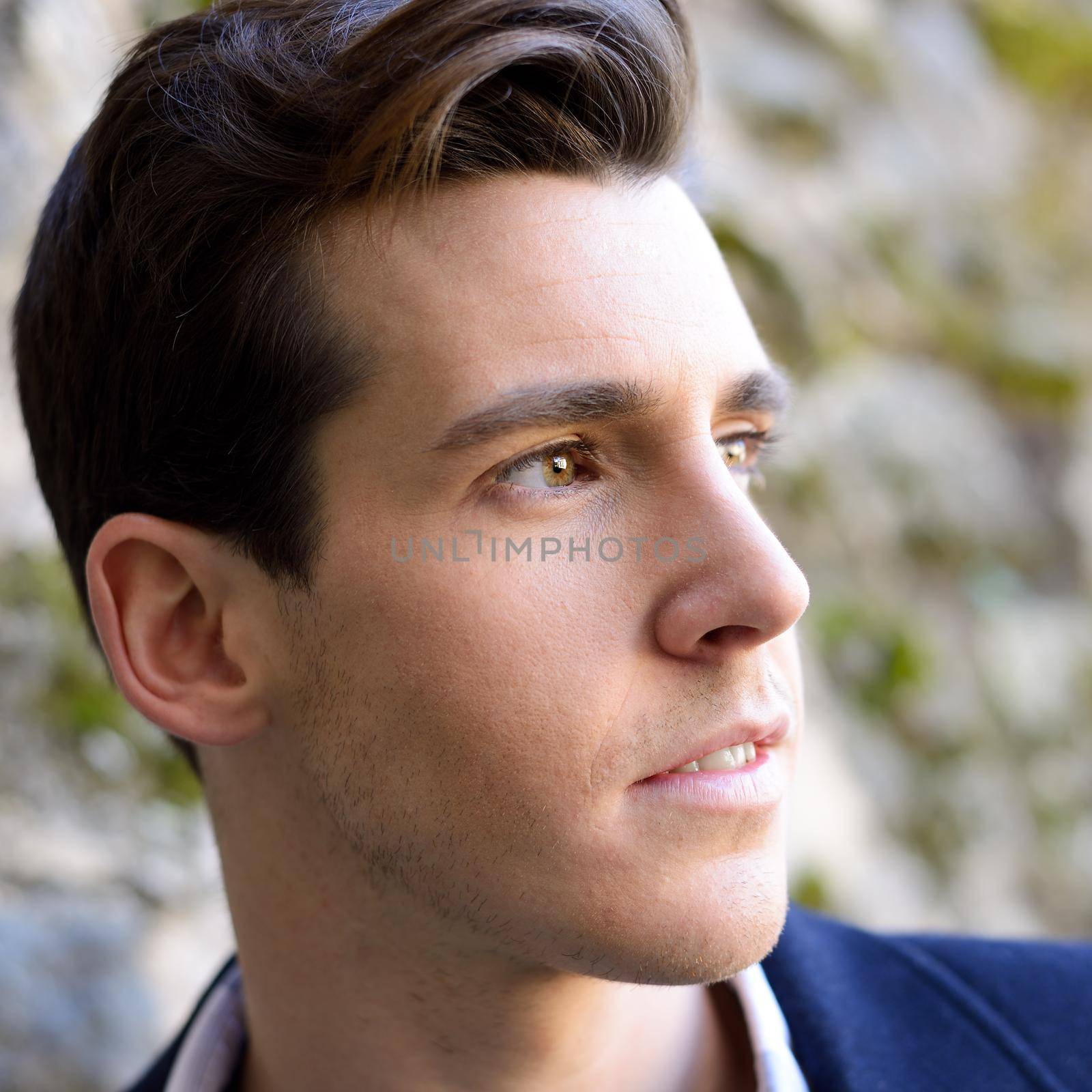 Handsome man with modern hairstyle smiling in urban background by javiindy