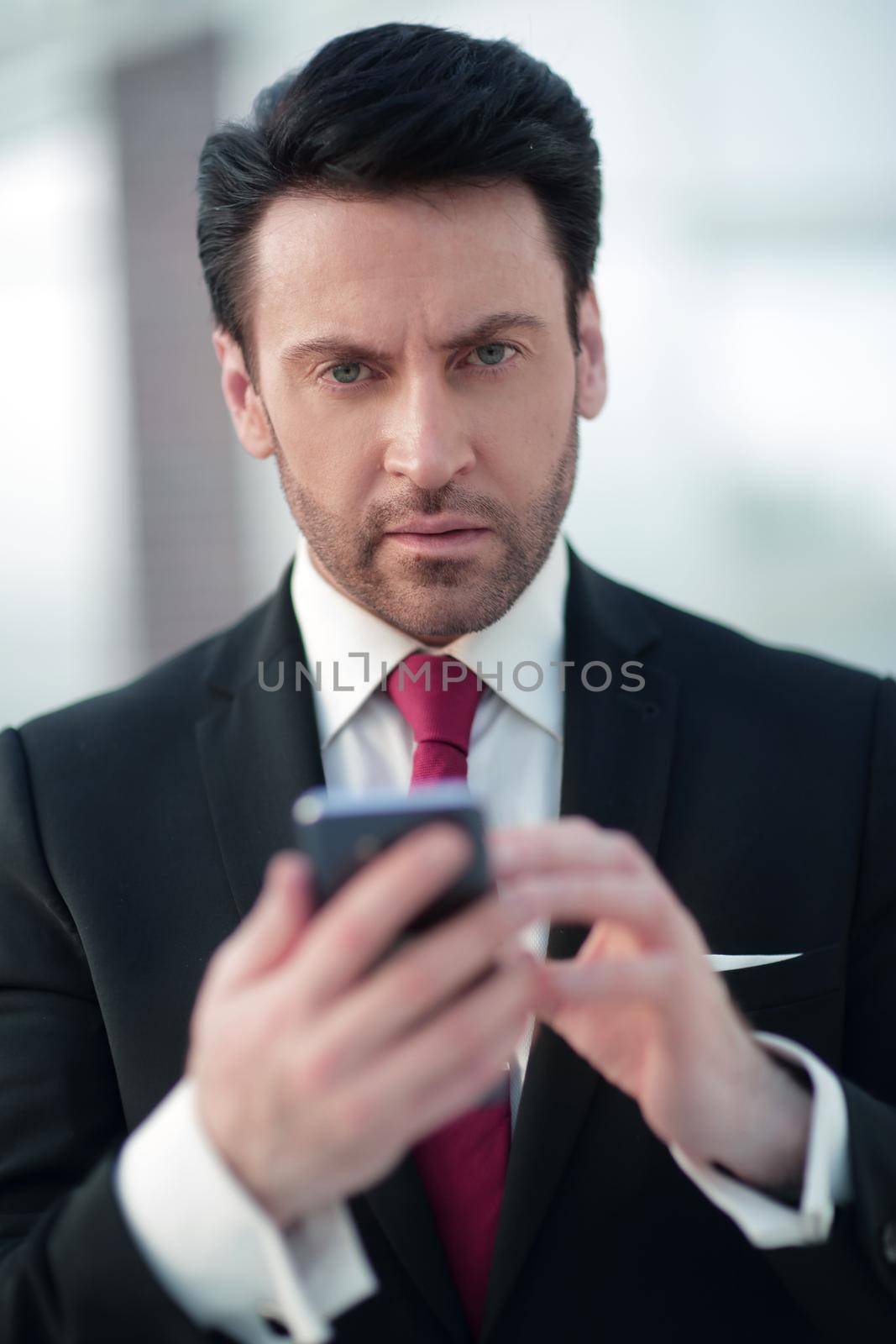 close up.businessman is typing SMS on a smartphone.people and technology