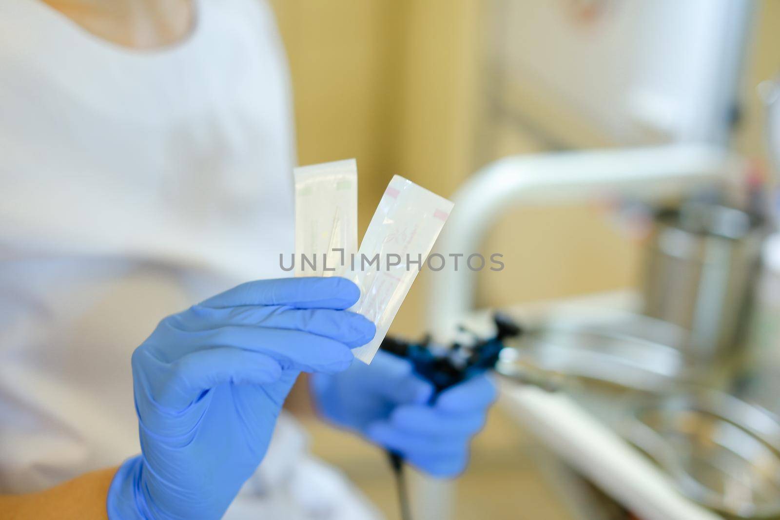 Closeup cosmetologist hands in latex gloves inserting needle into microblading device at beauty salon. Concept of cosmetology equipment for permanent makeup.