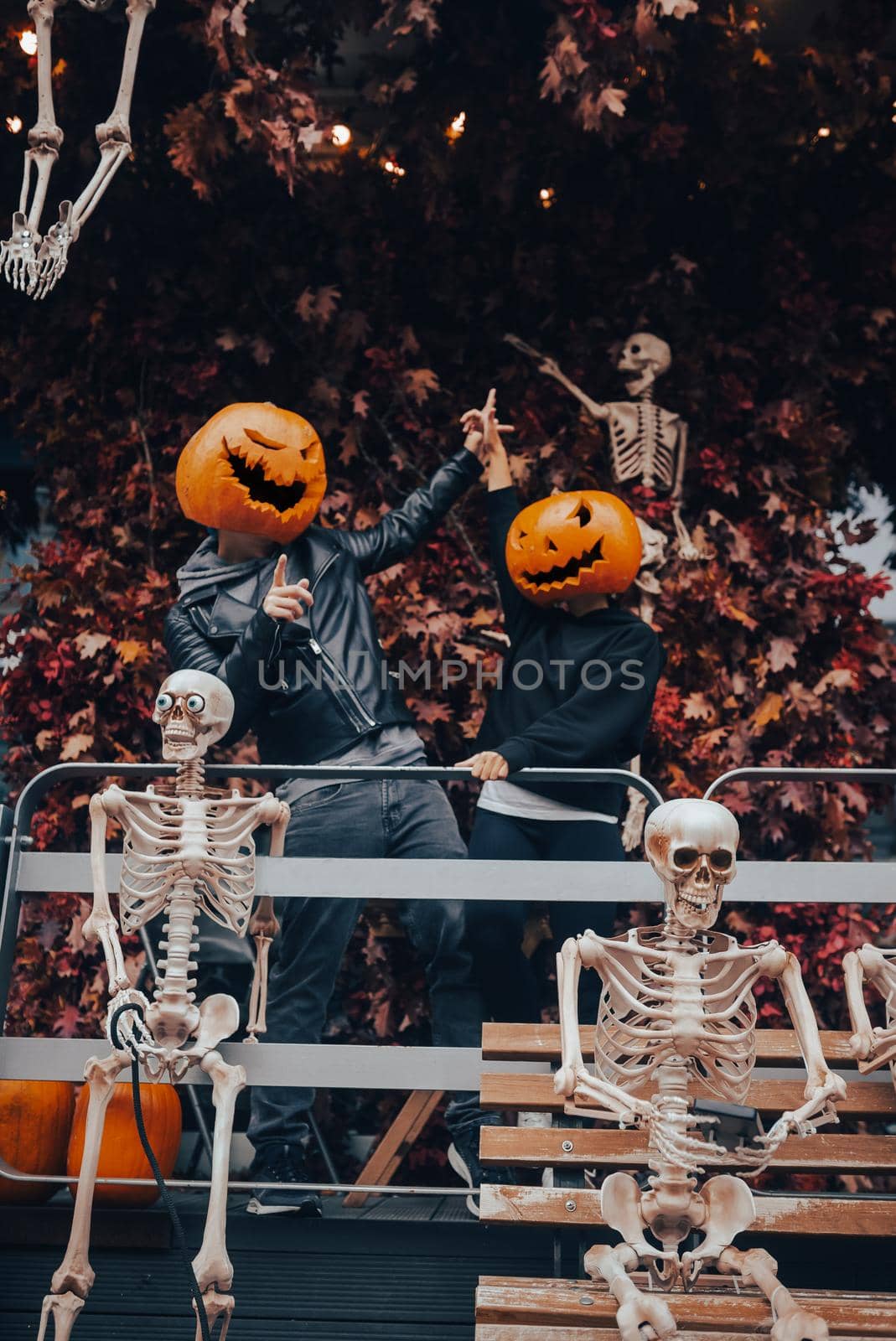 A guy and a girl with a pumpkin heads posing on the street . Halloween Concept