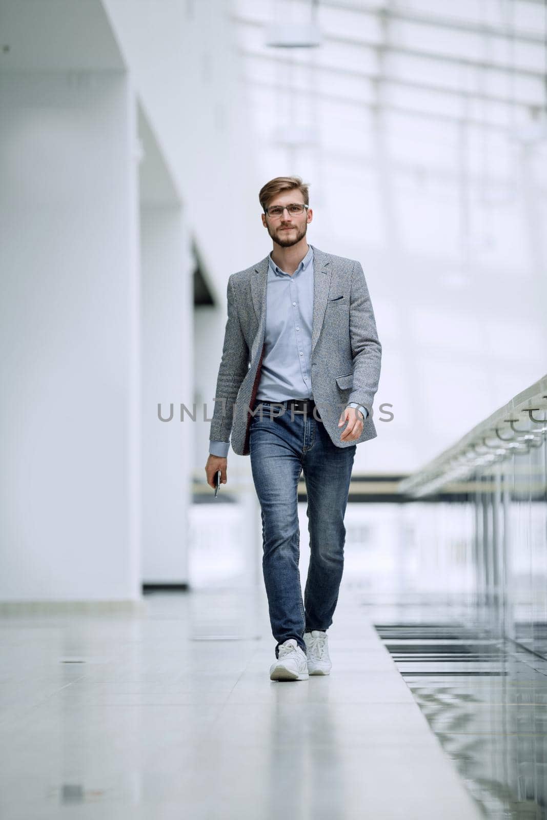 confident business man walks through a bright office. business concept