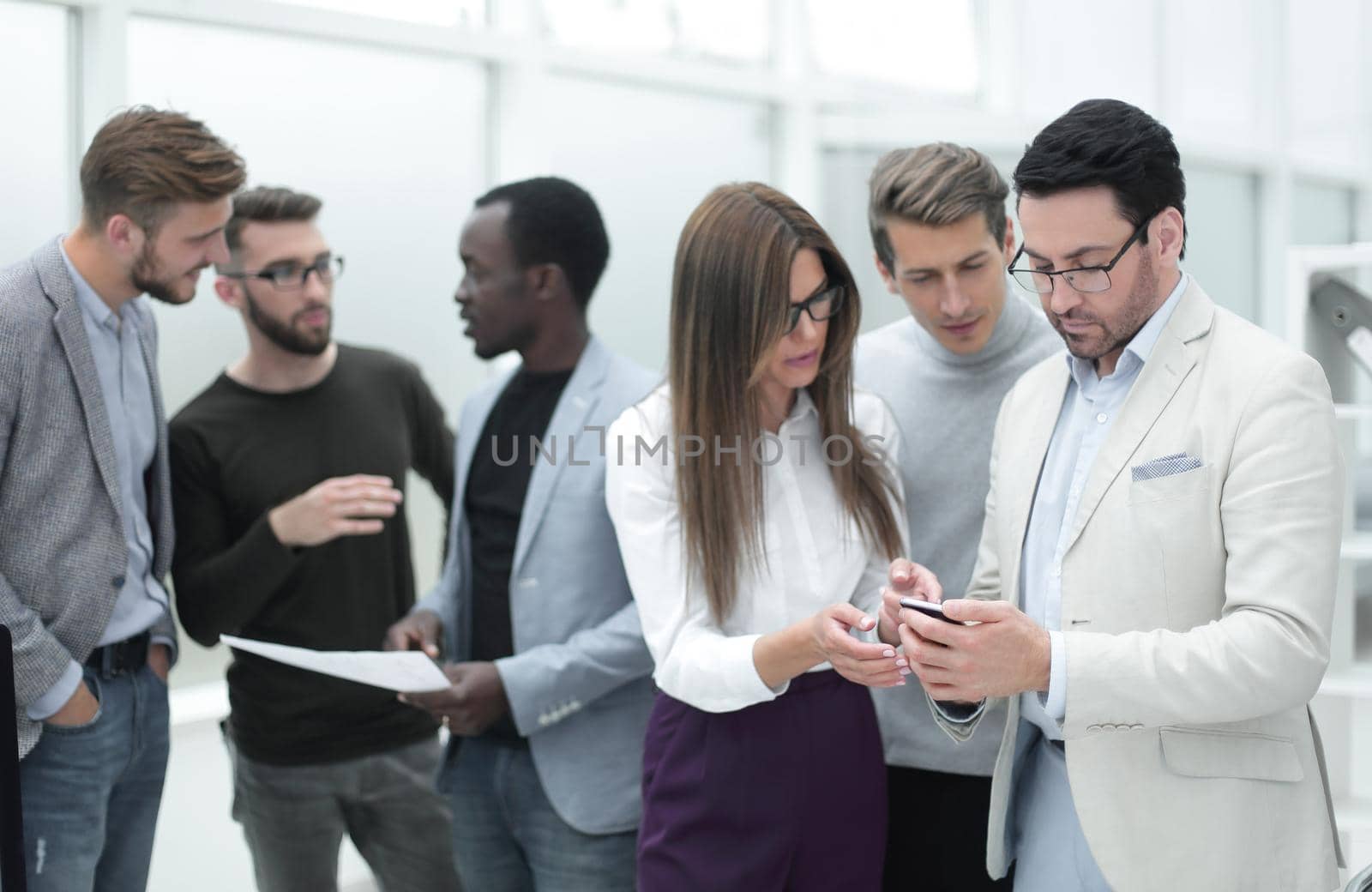 employees discuss working documents standing in the office.the concept of teamwork
