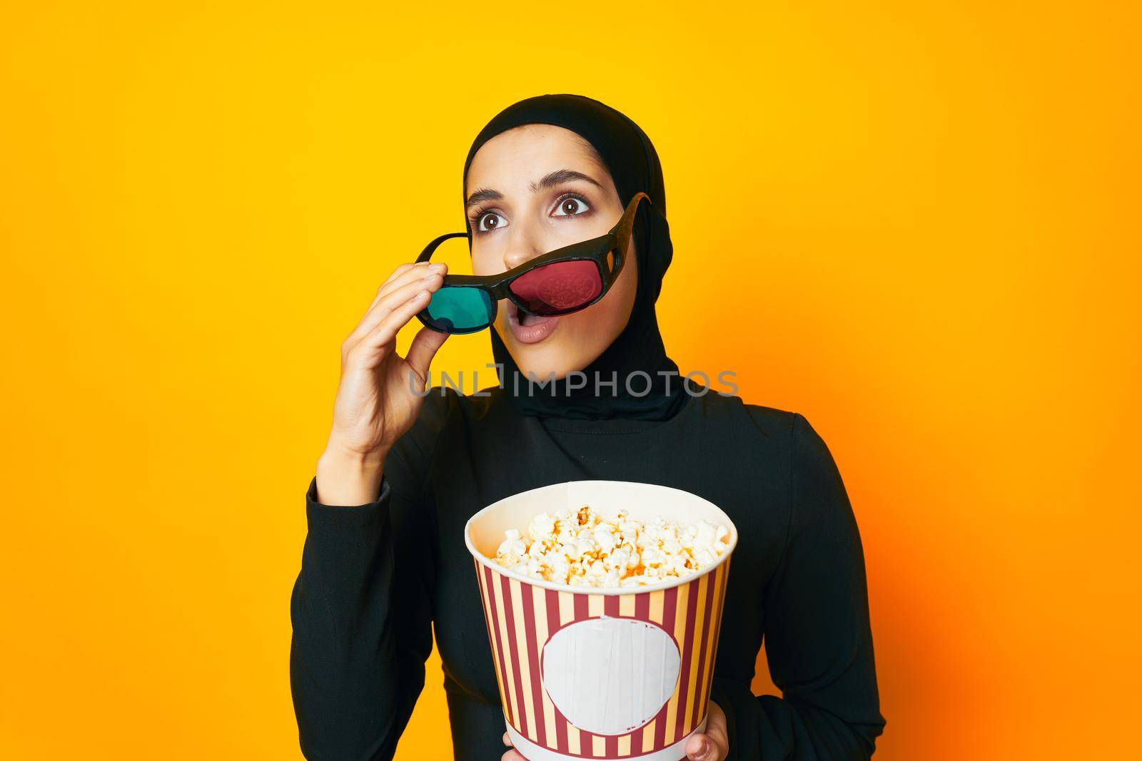 pretty woman in black hijab popcorn 3D glasses cinema ethnicity model. High quality photo