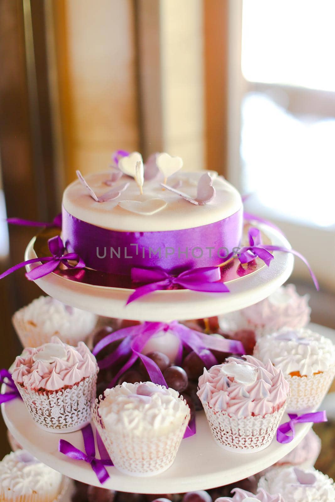 Violet decorations and sweet yummy cakes for party. Concept of birthday sweets and tasty food.