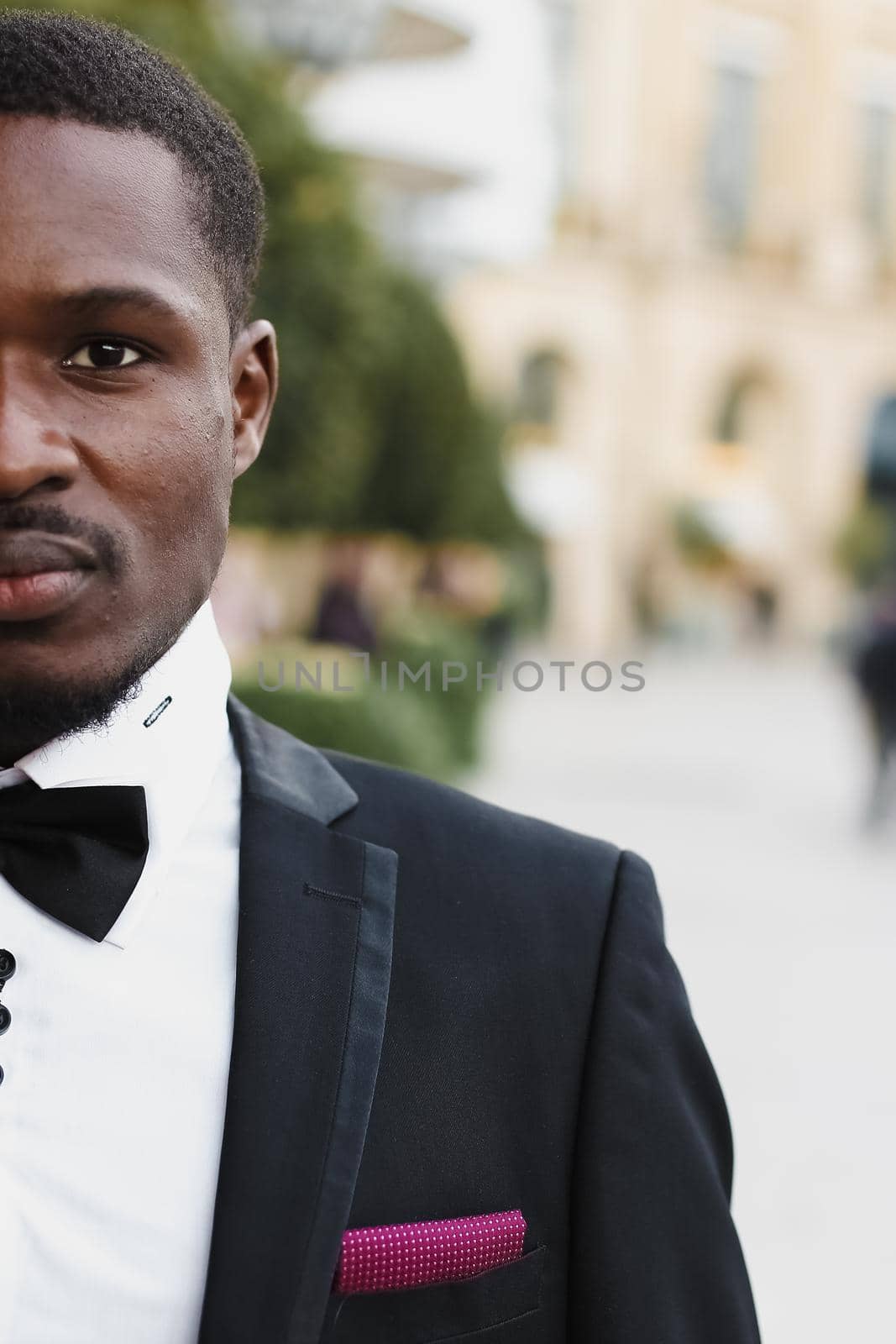 Afro american happy good looking man wearing suit and smiling outdoors. Concept of black businessman.