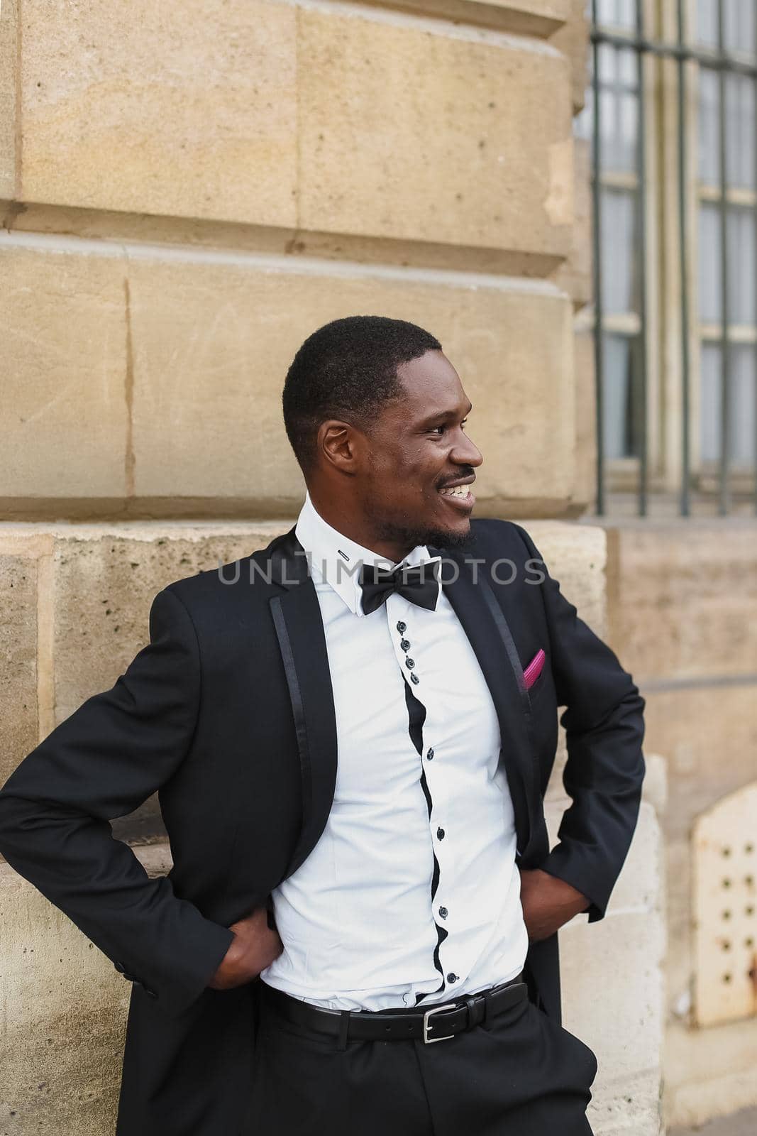 Afro american happy good looking man wearing suit and smiling outdoors. Concept of black businessman.