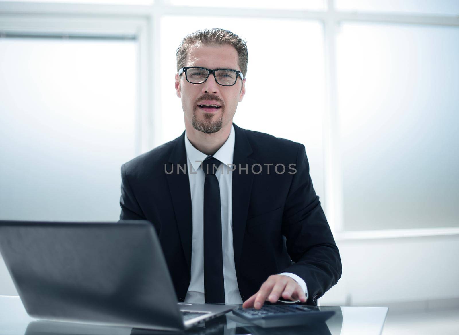 Portrait of bookkeeper or financial inspector adjusting his calculating or checking balance.