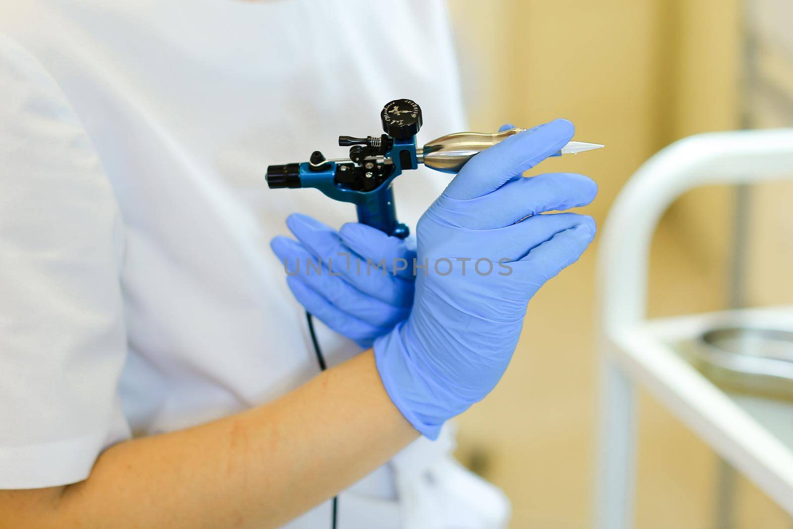 Close up cosmetologist hands keeping microblading device at beauty salon. by sisterspro