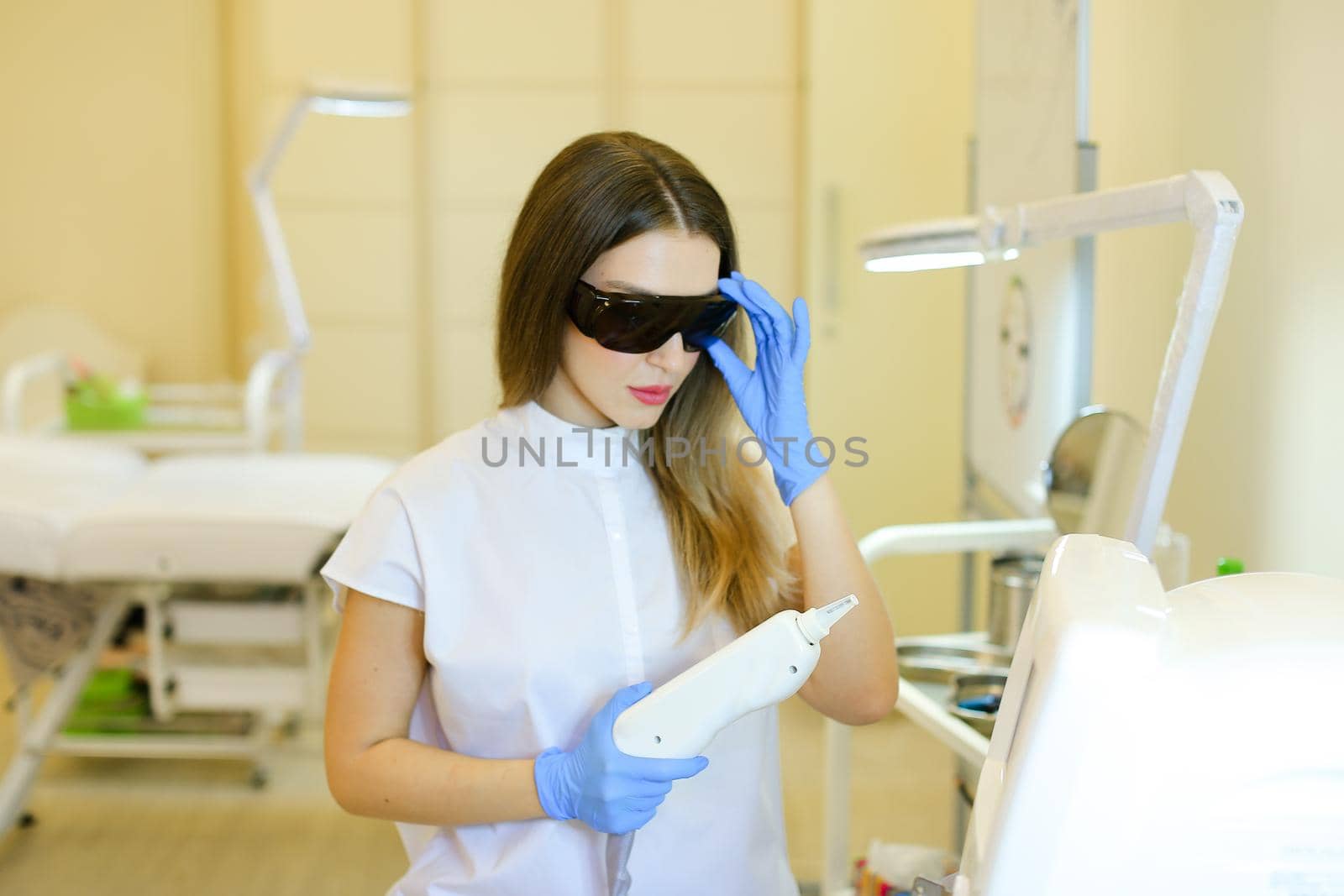 Caucasian cosmetologist making permanent makeup for girl at beauty salon. Concept of cosmetology equipment and microblading.