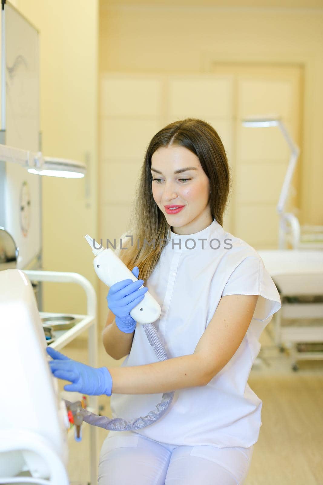 Caucasian permanent makeup artist sitting with laser removal of tatoos device at beauty salon. Concept of cosmetology equipment and cosmetologist.