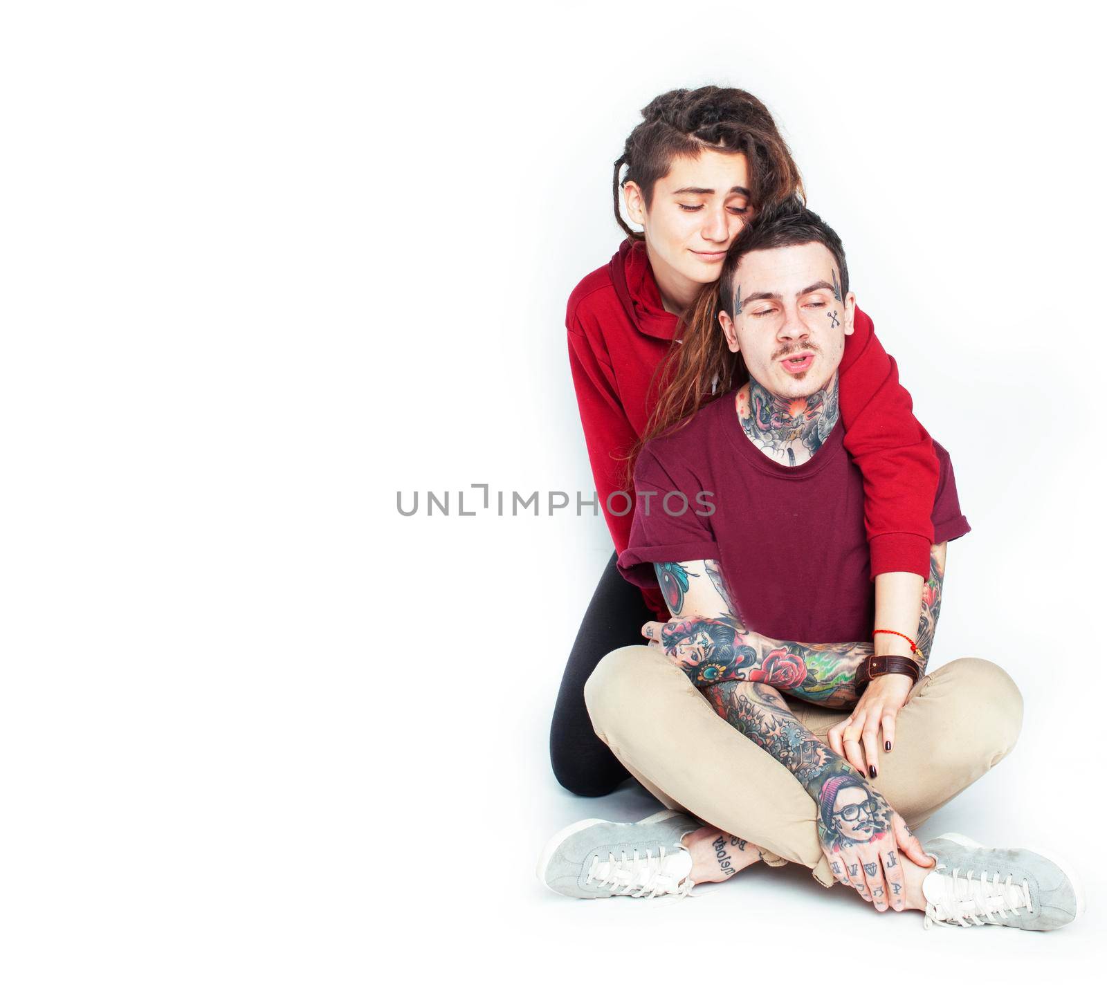 Young couple together. guy with tattoo, girlfriend wearing dreadlocks having fun on white background close up