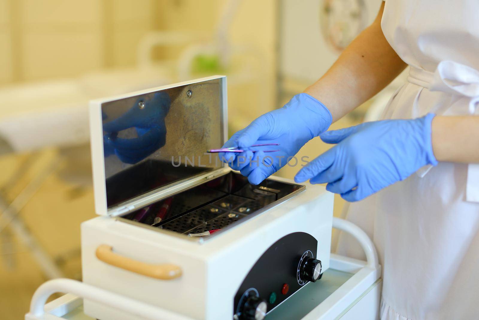 Close up cosmetologist hands in latex gloves disinfecting microblading pen tool at beauty salon. Concept of permanet makeup artist and cosmetology equipment.