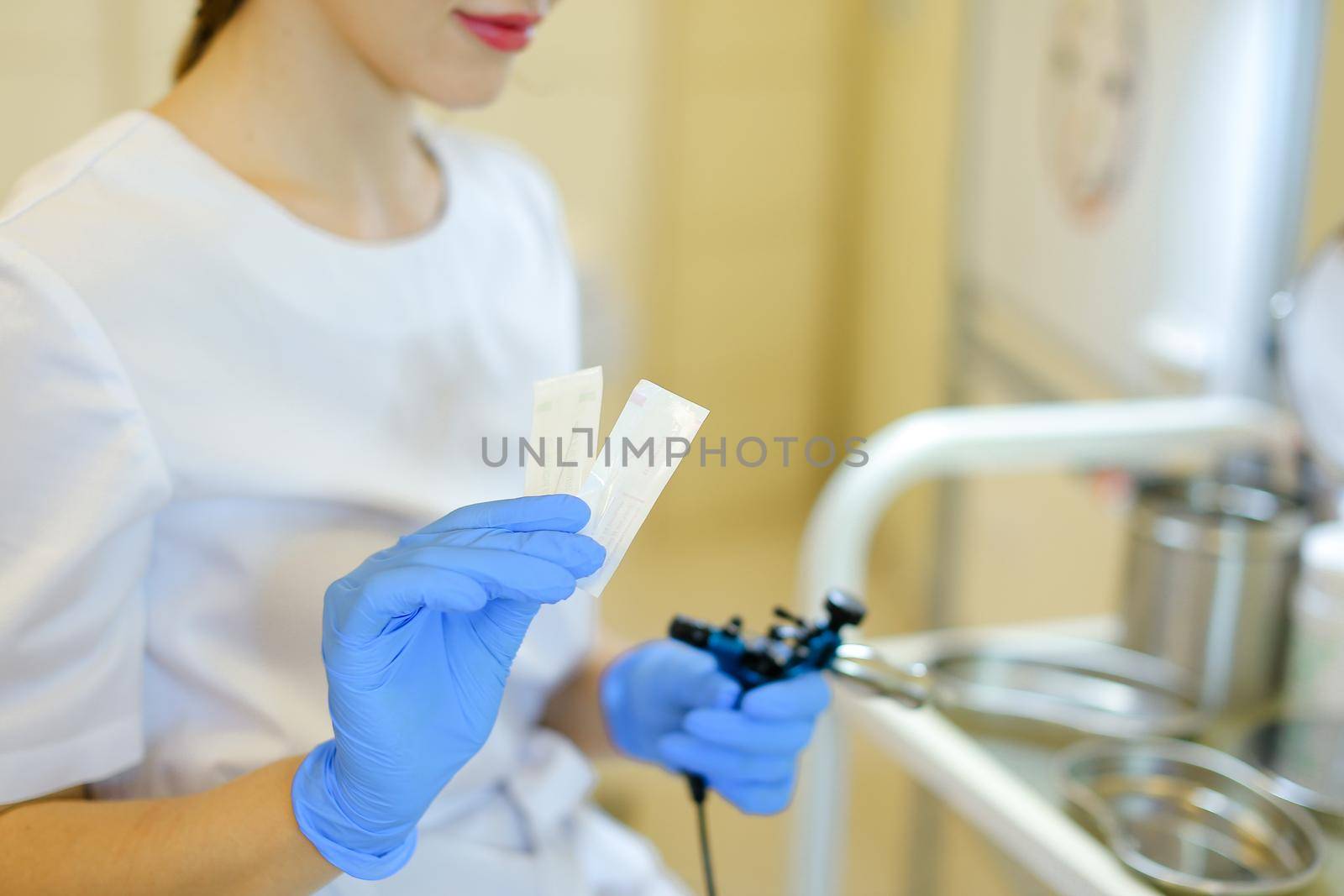 Female cosmetologist inserting needle into microblading device at beauty salon. Concept of cosmetology equipment for permanent makeup.