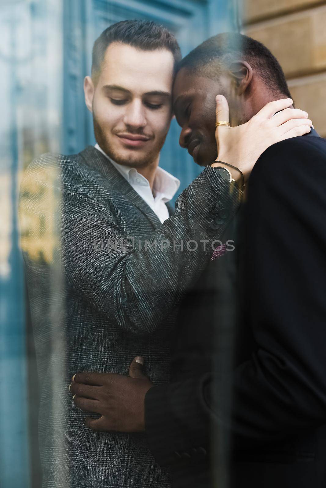 Reflection in glass of two kissing men, afro american and caucasian. by sisterspro