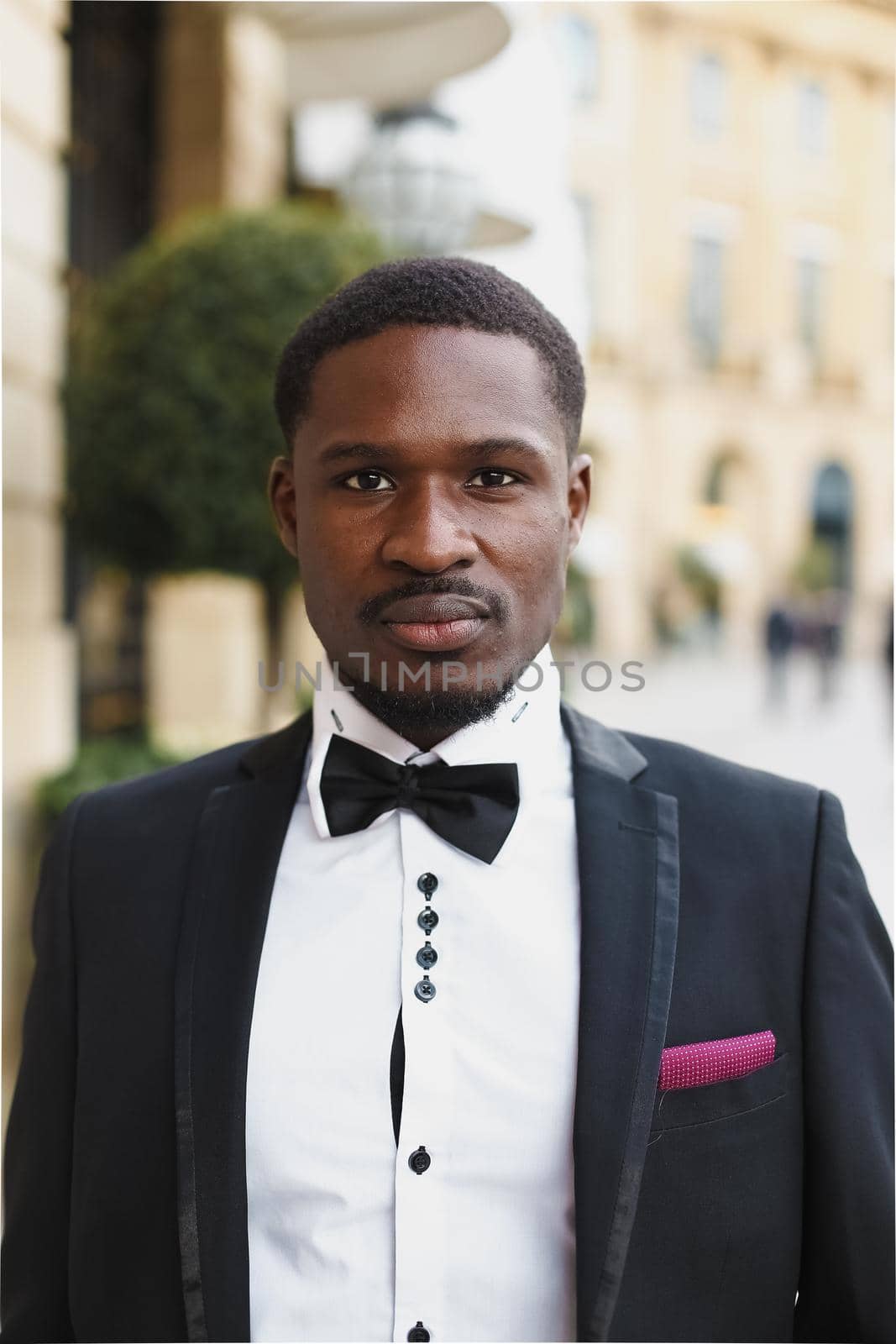 Afro american man wearing suit and standing near building. by sisterspro