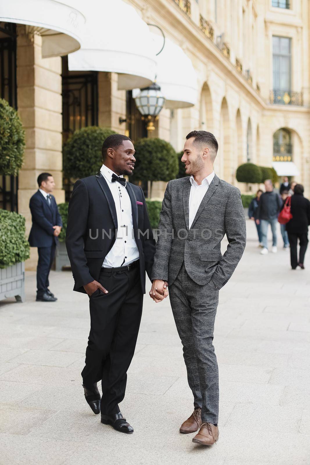 Afro american and caucasian stylish gays walking outside. by sisterspro