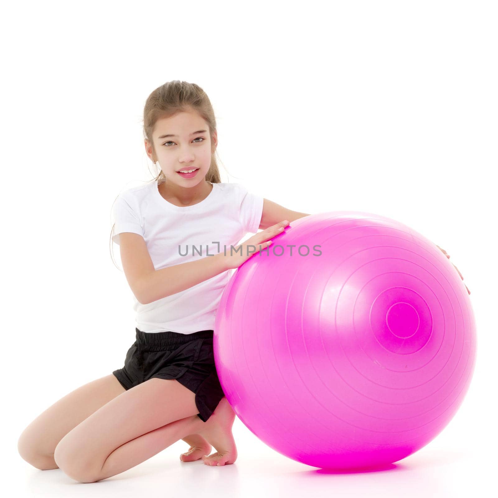 little girl doing exercises on a big ball for fitness. by kolesnikov_studio