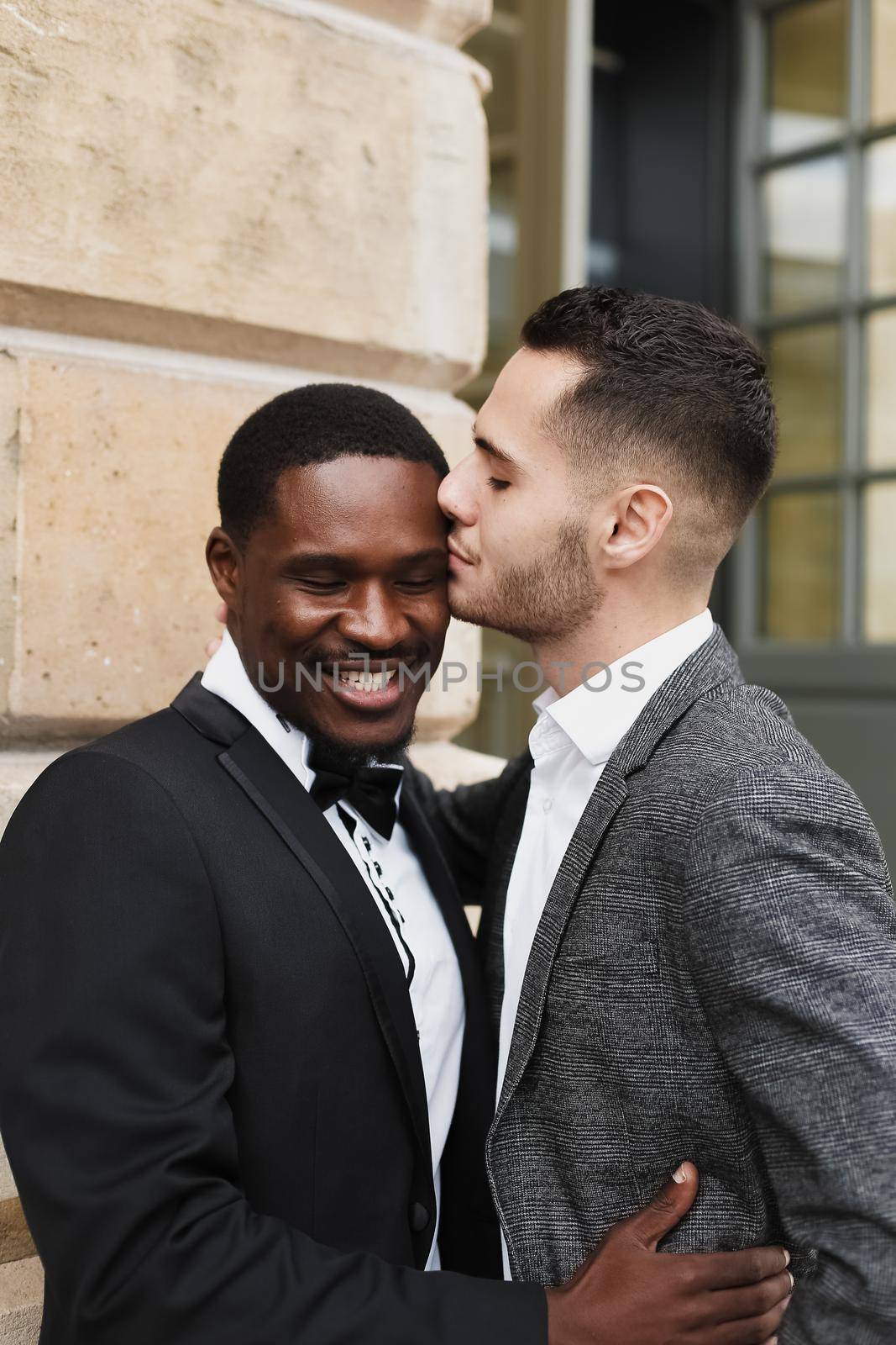 Afro american gay hugging and kissing european man outside. by sisterspro