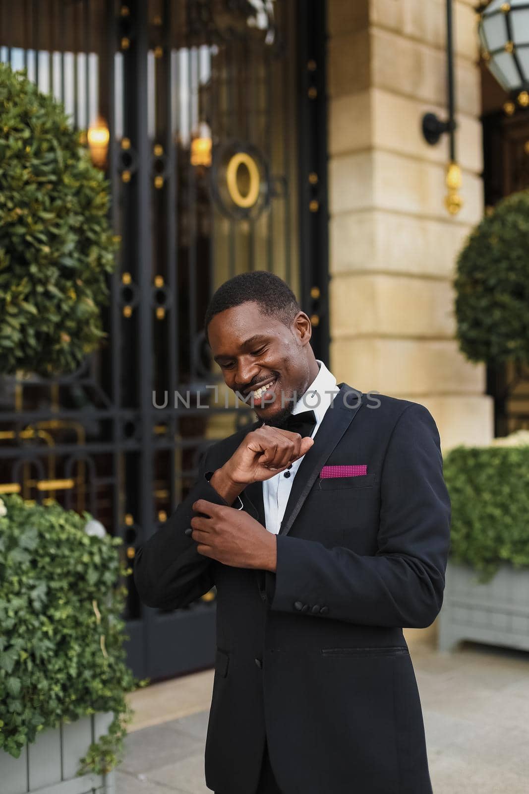 Afro american happy good looking man wearing suit and smiling outdoors. Concept of black businessman.