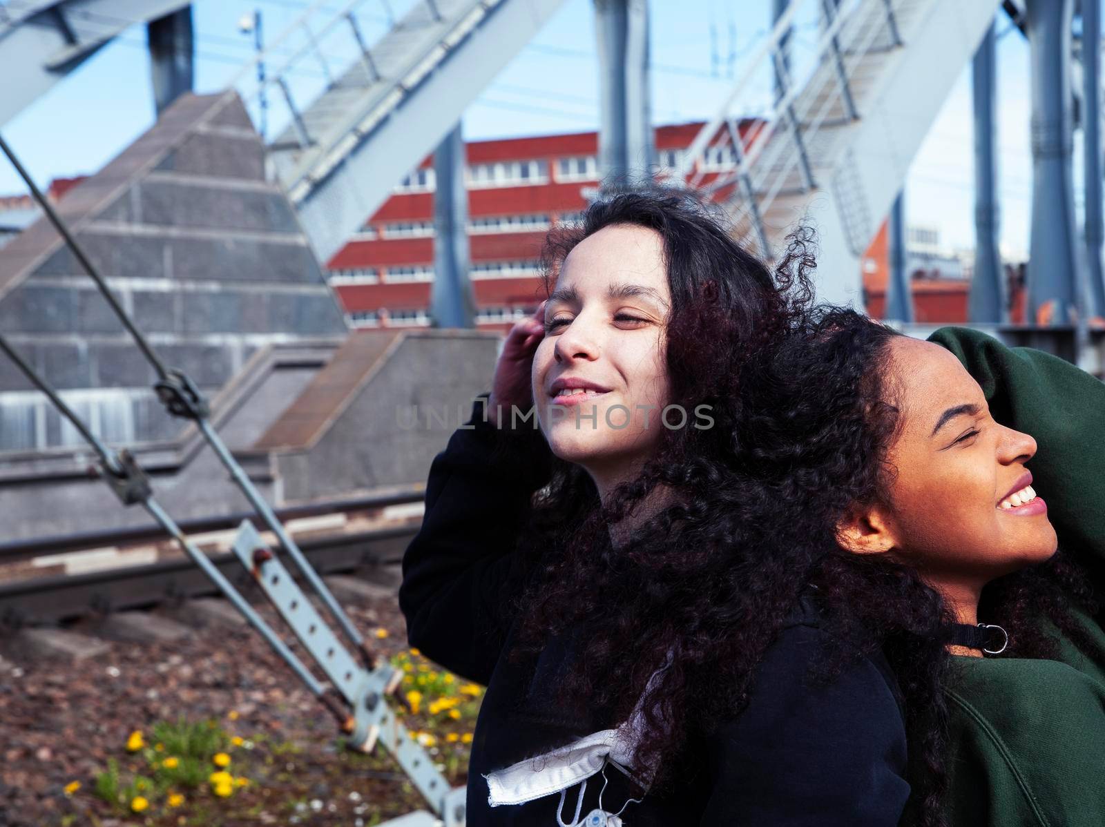 young cute teenage girls together in industrial zone happy smiling having fun, big city lifestyle fashion people close up