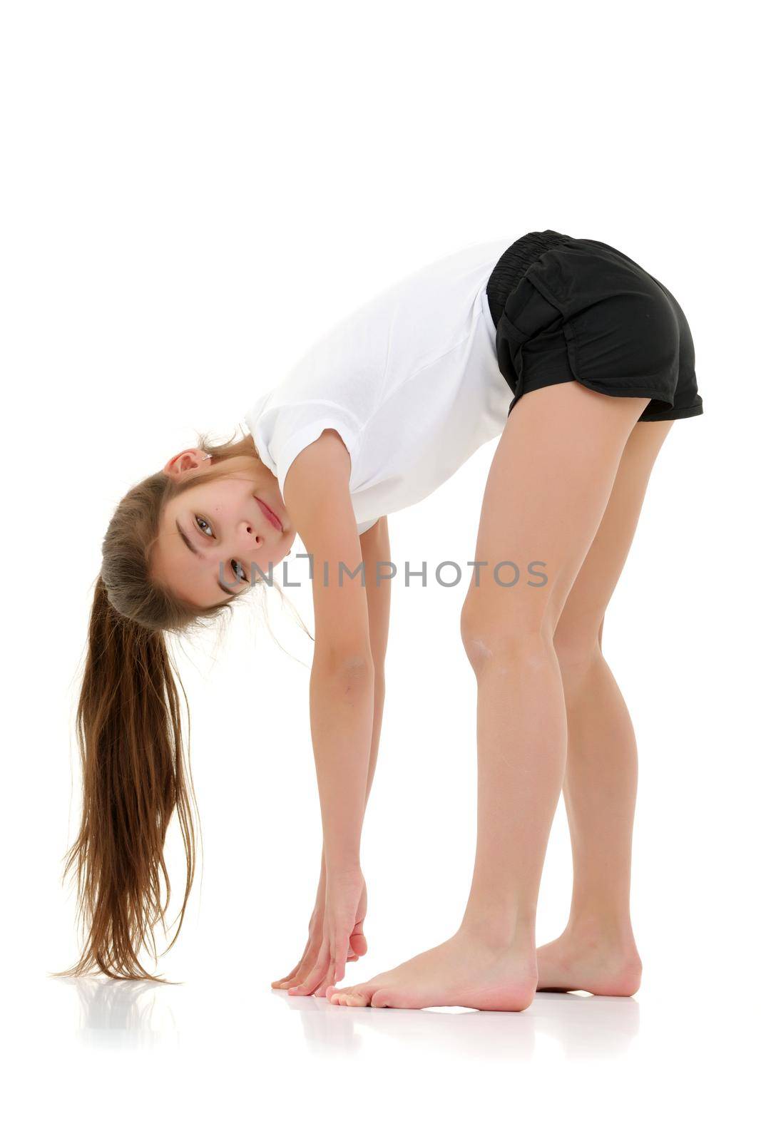 A girl gymnast performs an acrobatic element. The concept of childhood, sport, healthy lifestyle. Isolated on white background.