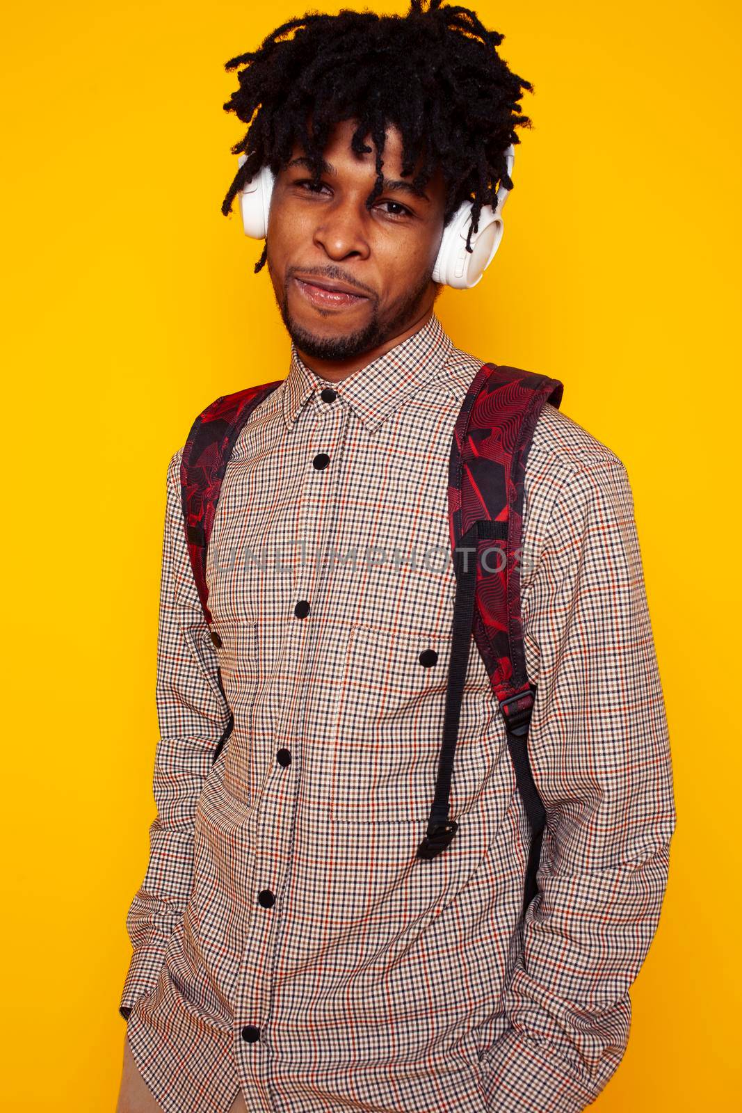 young handsome african american guy student posing cheerful and gesturing on yellow background, lifestyle people concept close up