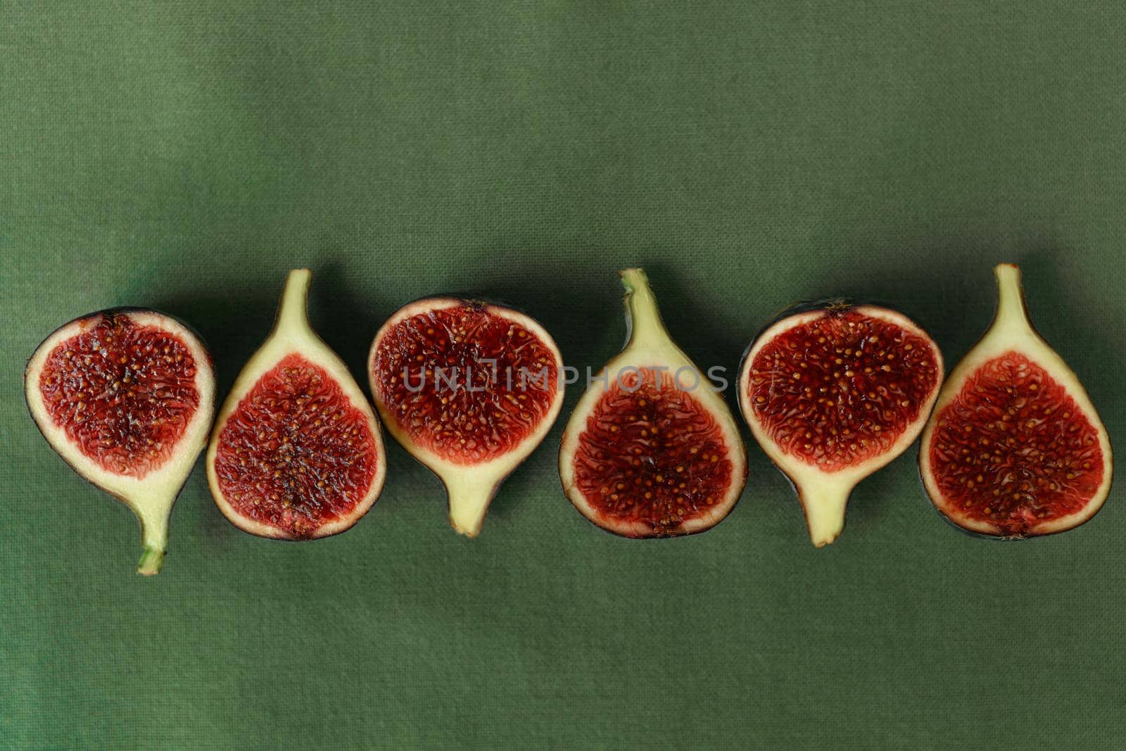 Sliced figs on the background of a green napkin top view.