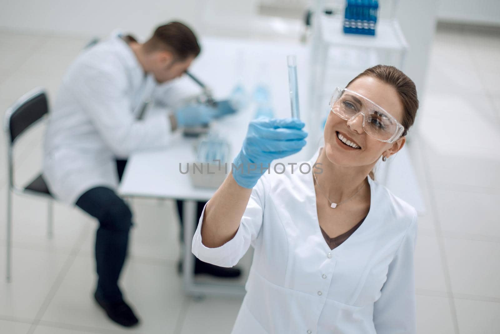 serious female scientist looks at the tube with the results of the analysis.photo with copy space