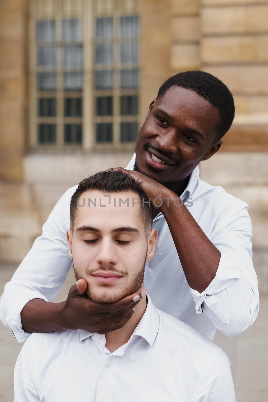 Afro american boy holding caucasian guy head by hands. by sisterspro