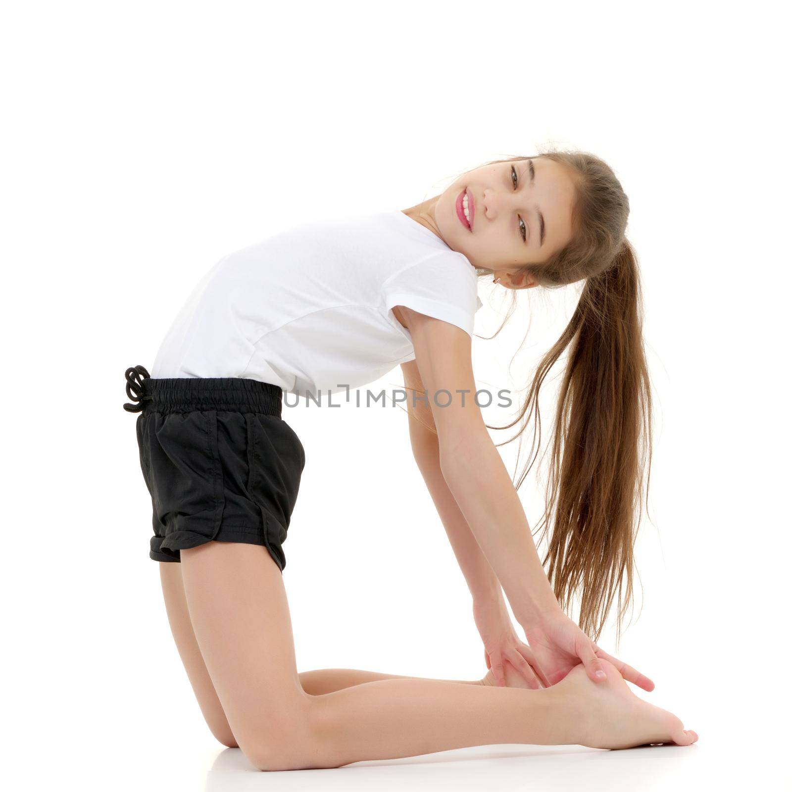 A gymnast girl prepares for the exercise. The concept of childhood and sport, a healthy lifestyle. Isolated on white background.