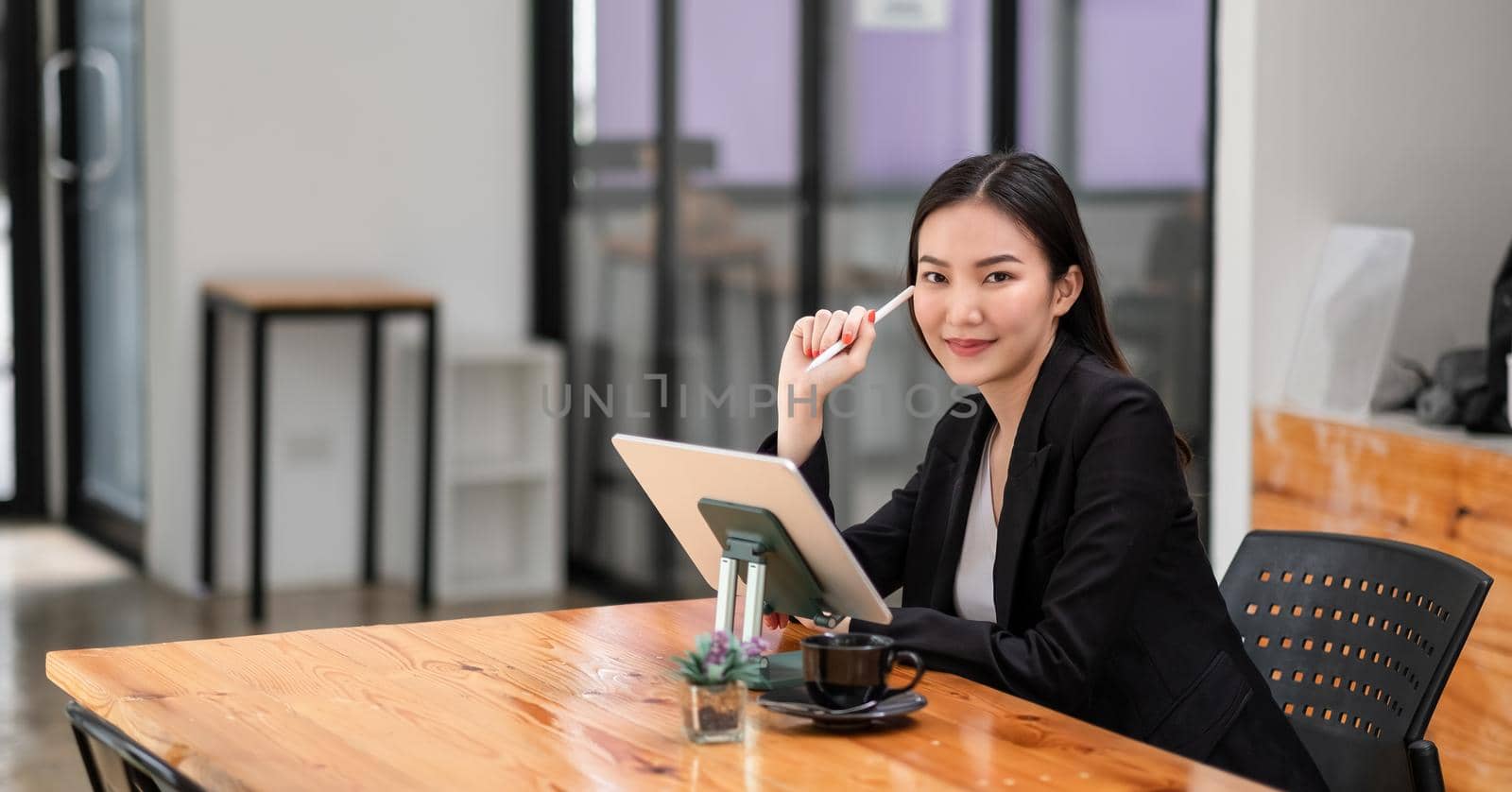 Portrait Of Asian Businesswoman Working with digital tablet at cafe shop.