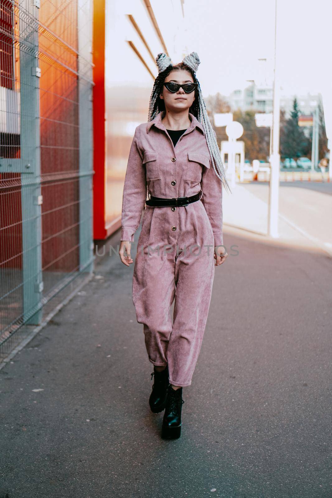 Beautiful cool girl with dreadlocks full length. Photo in the city - urban style