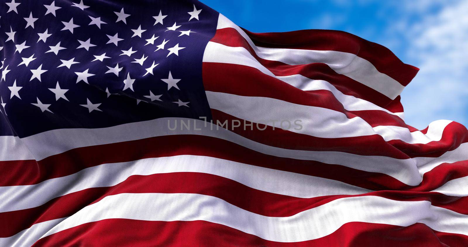 close up view of the american flag waving in the wind. Clear sky in the background. Selective focus. Democracy, independence and election day. Patriotic symbol of American pride