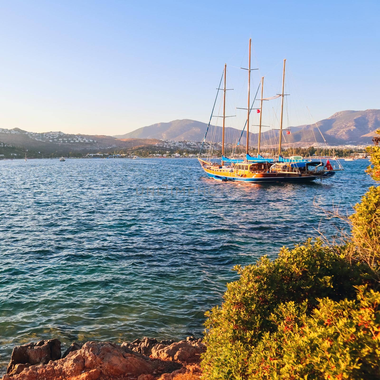 Beautiful Mediterranean coast with islands, mountains and yacht at sunset by Olayola