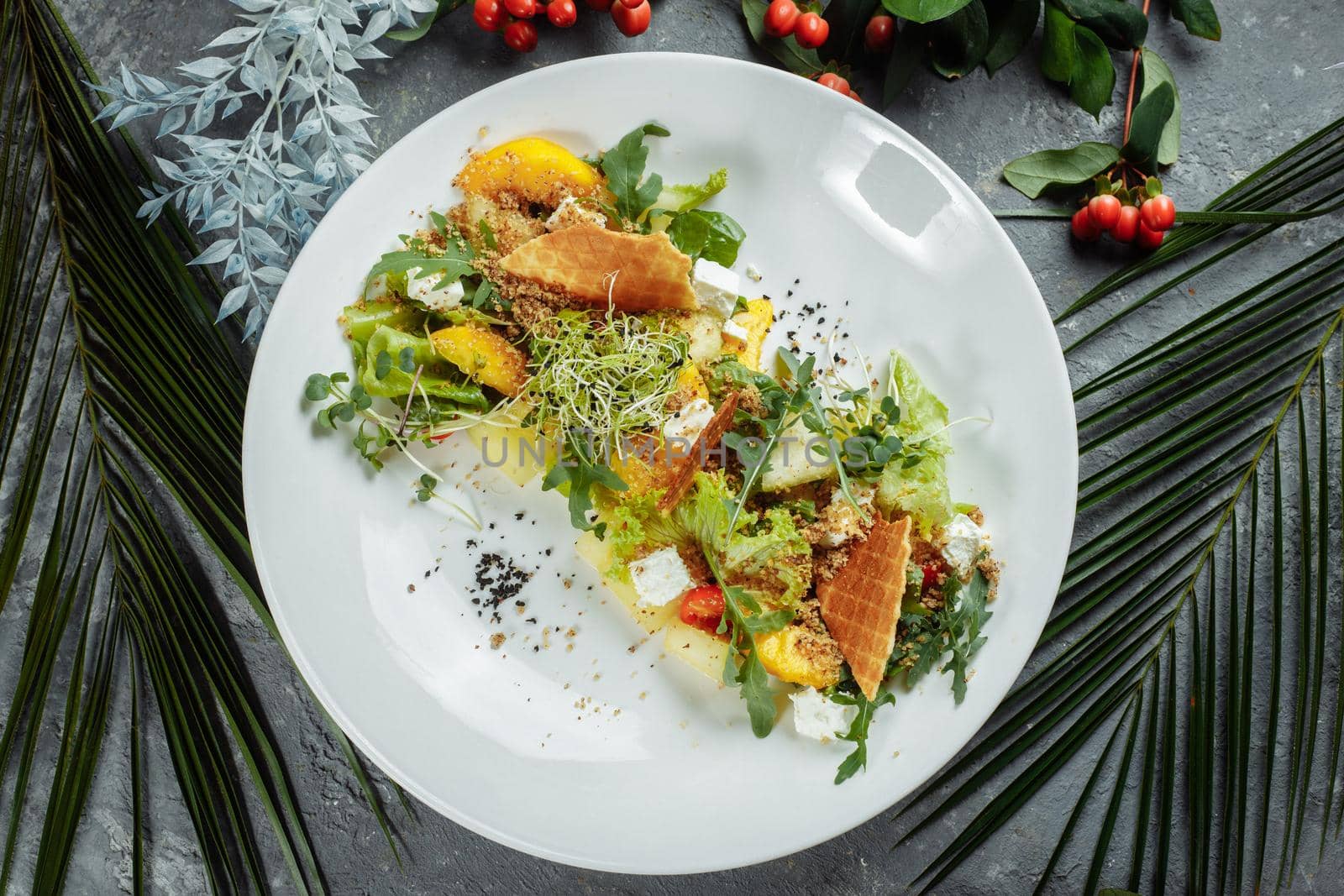 Summer diet salad with leaves of lettuce, watermelon, peach and feta cheese. On a light blue background copy space by UcheaD