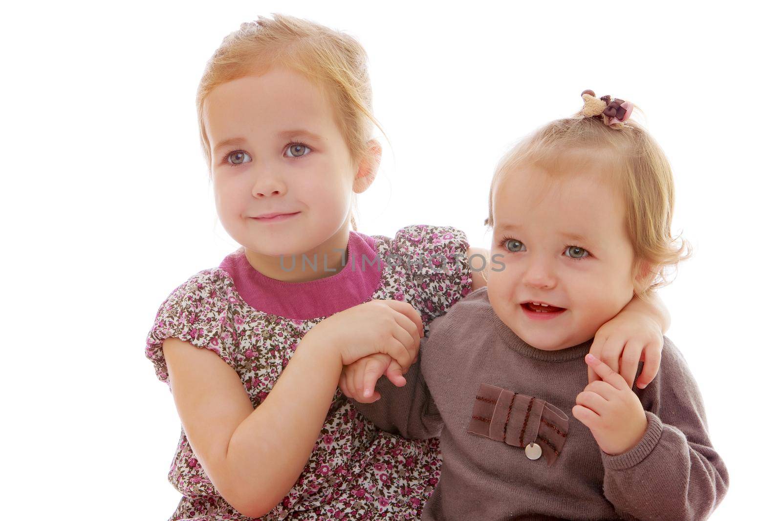 Two cute little girls close-up, in the studio on a white background. The concept of a happy childhood, Beauty and fashion. Isolated.