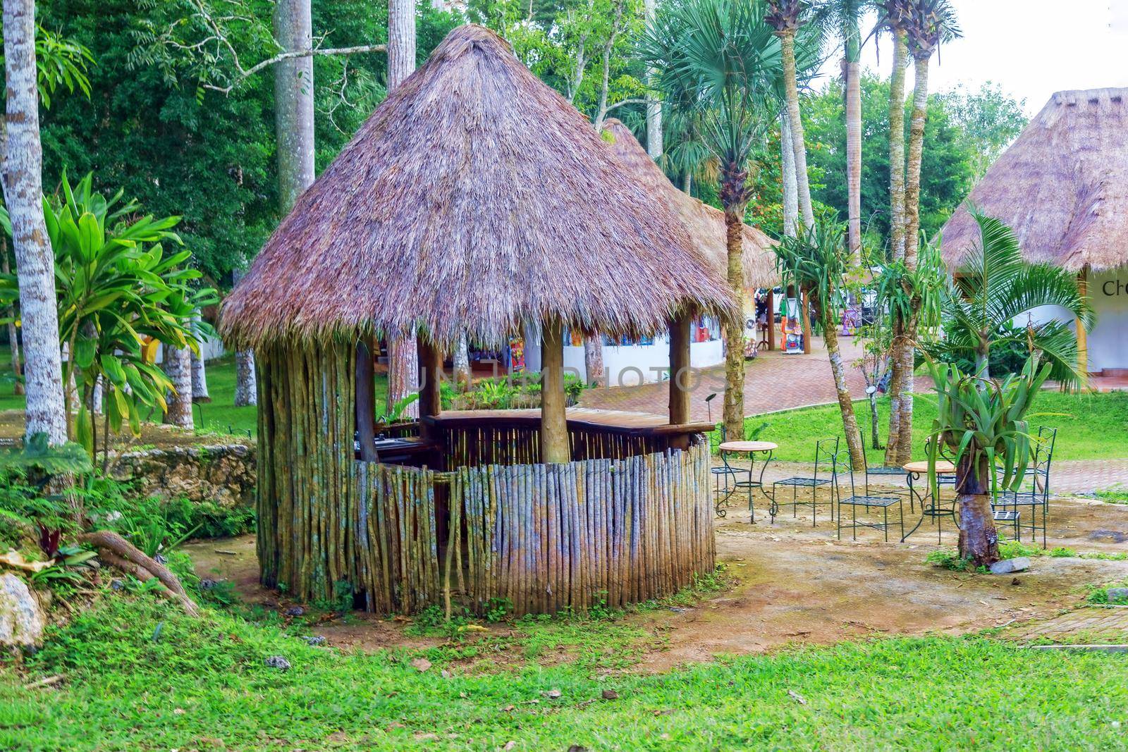 Romantic gazebo in the park with thatched roof. The concept of a family holiday, tourism.