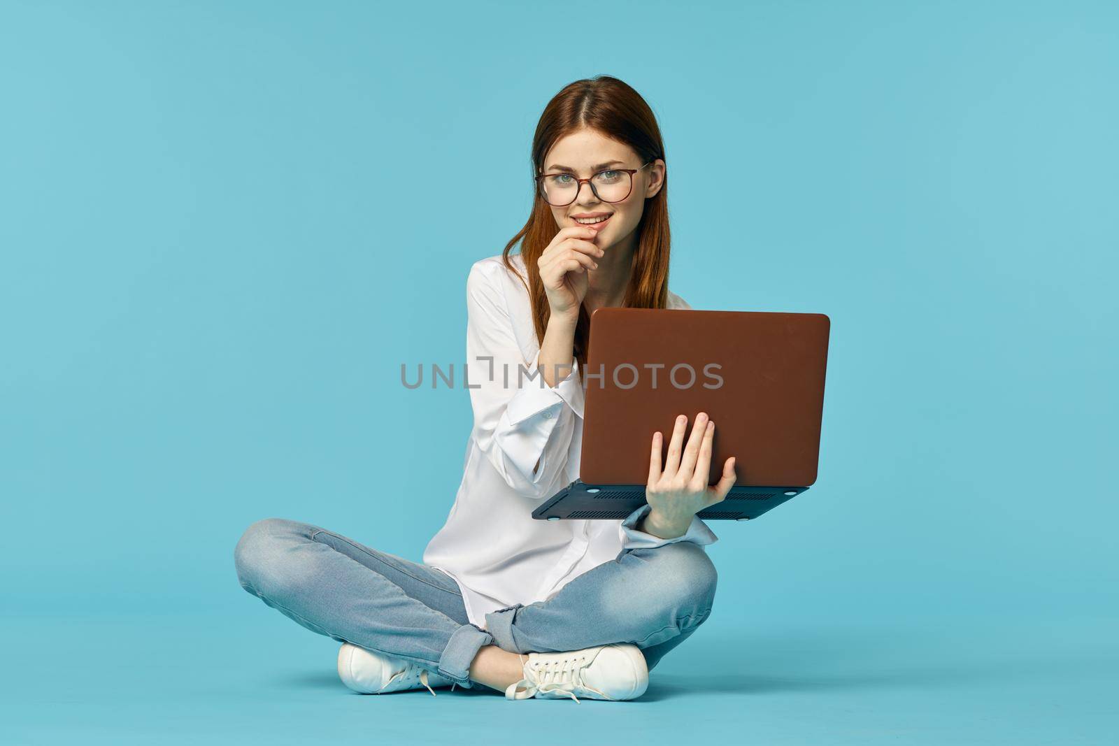 woman with laptop learning internet online education blue background. High quality photo