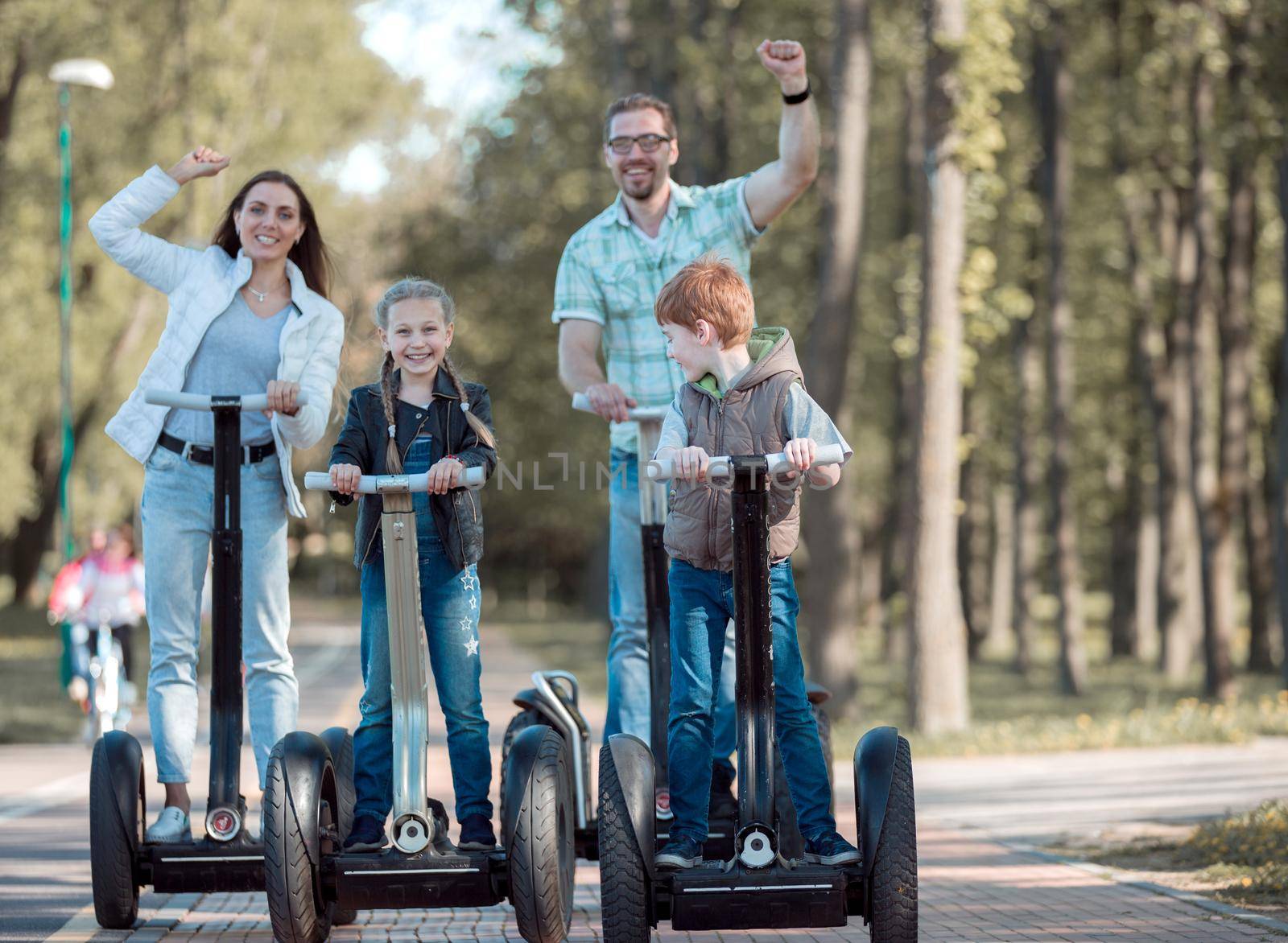 modern family riding an electric mini hoverboard in the Park. We go together.