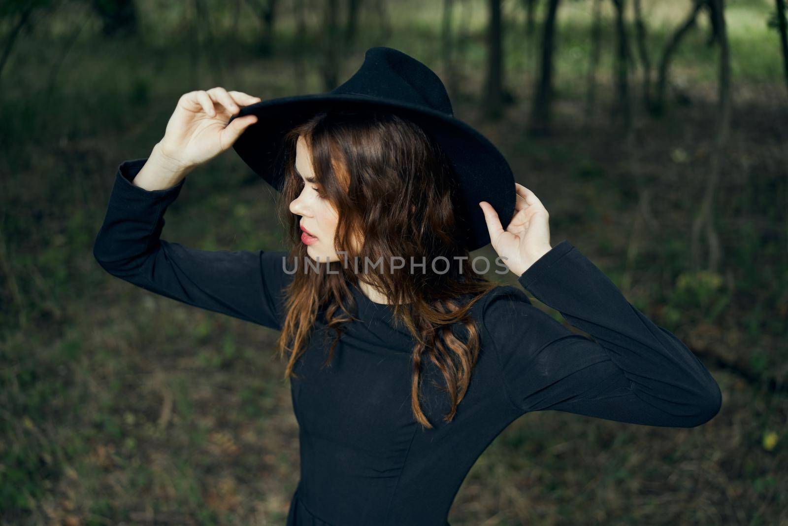 woman in the forest in a black hat gothic style Witch costume by Vichizh