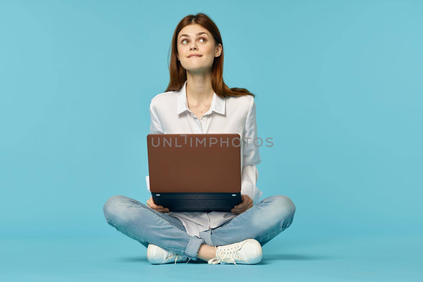 woman with laptop learning internet online education blue background. High quality photo