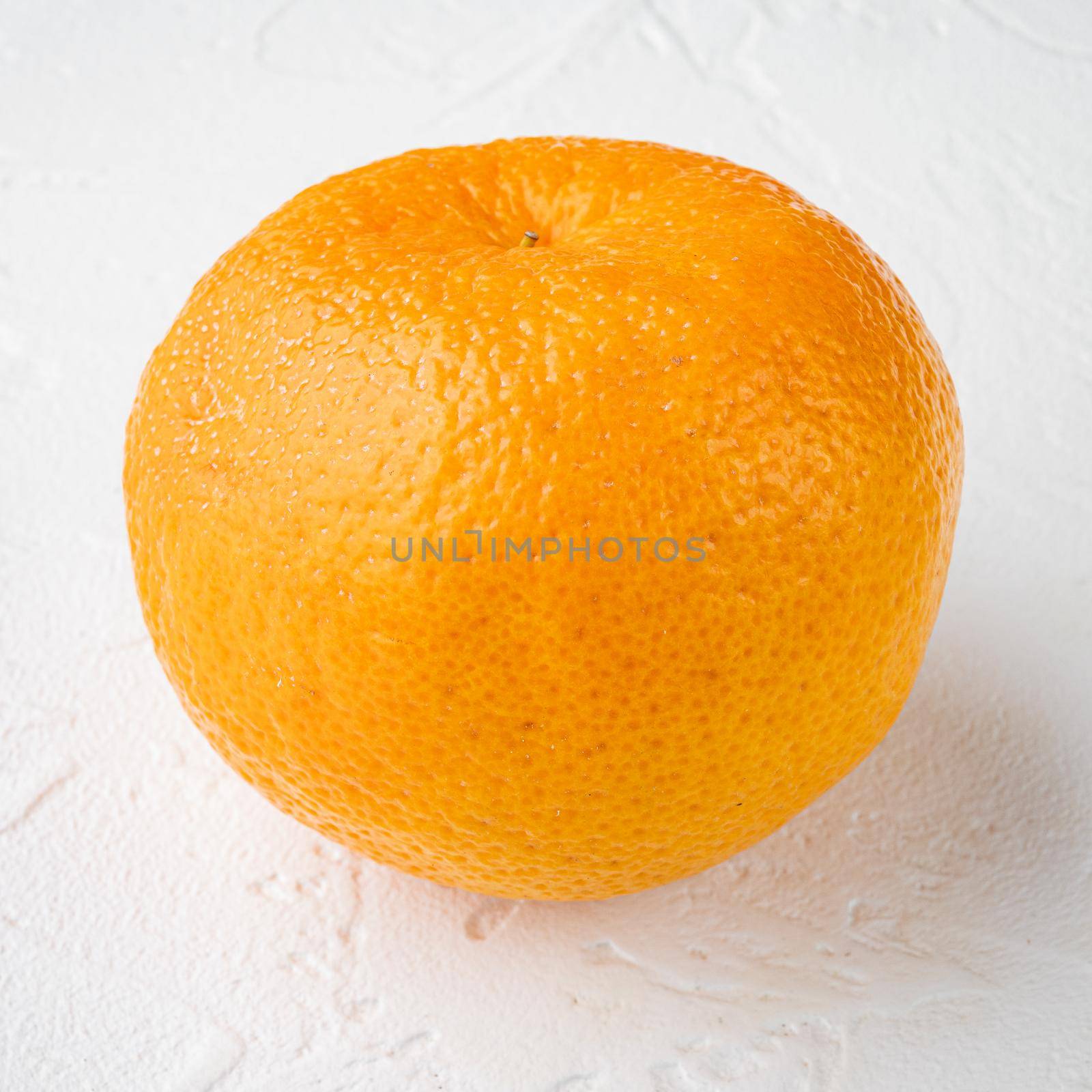 Tangerine whole, on white stone table background, square format by Ilianesolenyi