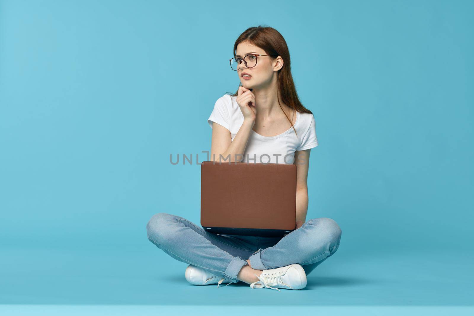 woman with laptop learning internet online education blue background. High quality photo